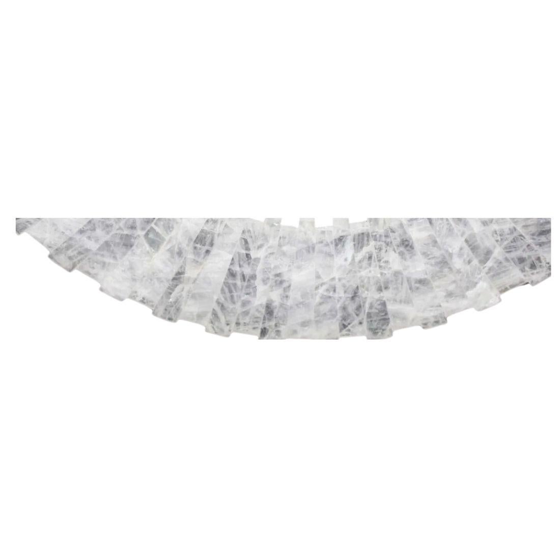 Uno specchio vintage in cristallo di rocca con un bordo di pezzi di cristallo bianco di profondità alternata per creare uno splendido specchio decorativo.