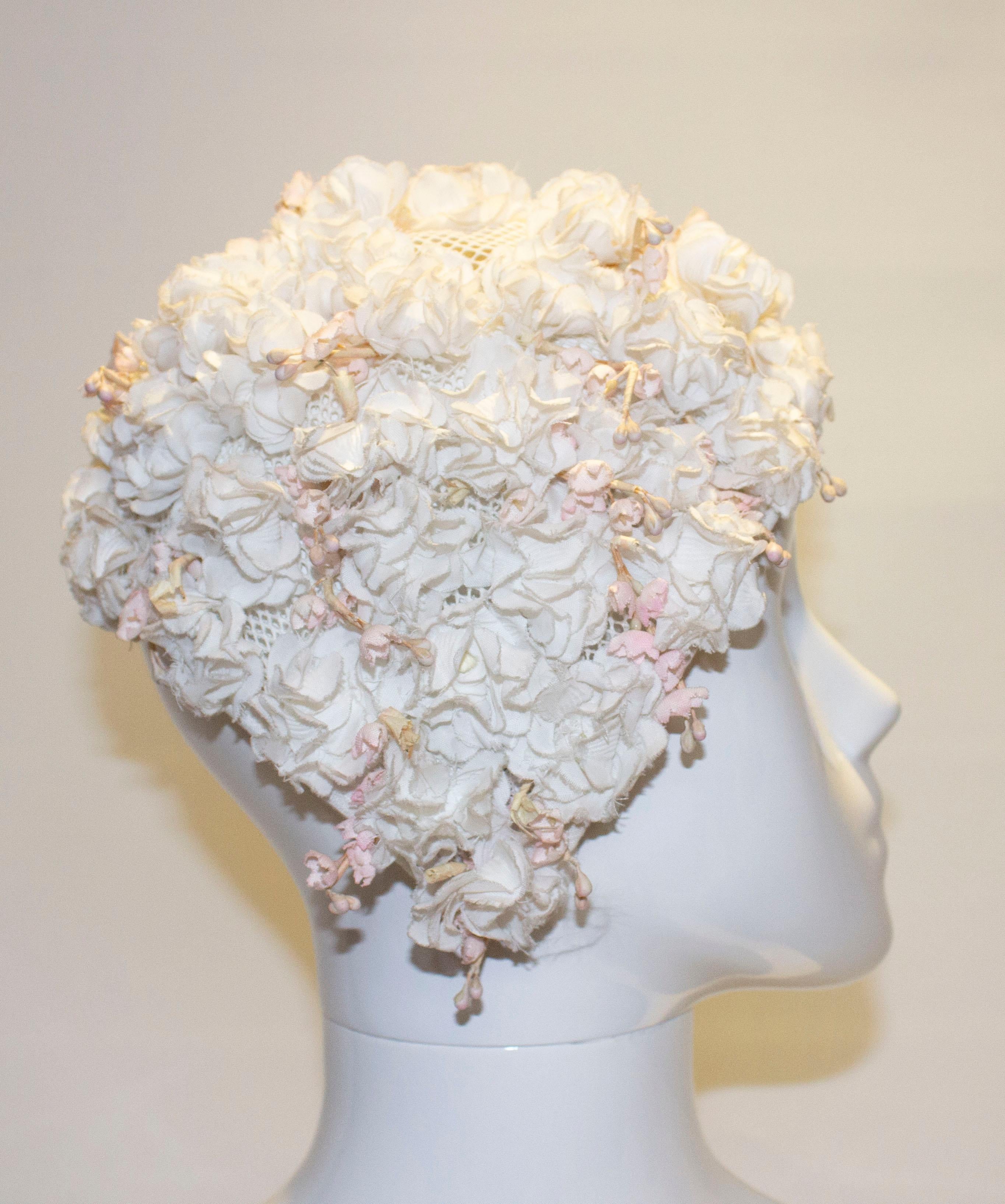 A fun vintage hat ,the hat is covered in white flowers and pink buds on a net frame. There are a couple of bare patches but these can be filled in.