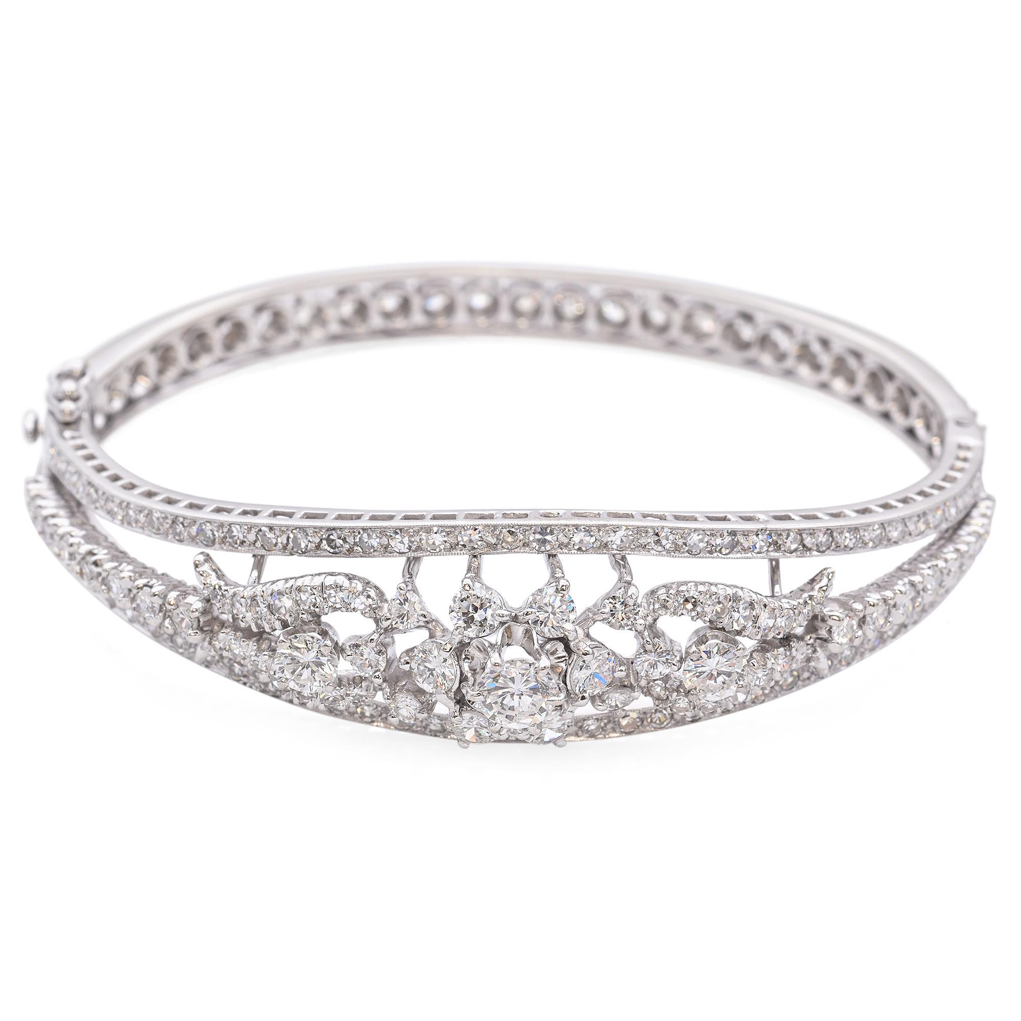 Ce bracelet exquis présente un arrangement central de diamants ronds de taille brillant, méticuleusement sertis pour créer un point focal éblouissant. Le design ajouré complexe est orné de diamants plus petits, rehaussant l'éclat et l'élégance de