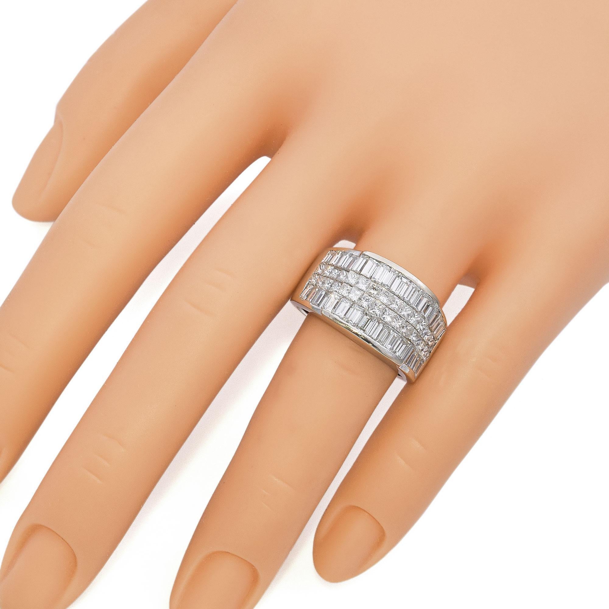 This striking ring is crafted in white gold. The design features two rows of pricess-cut diamonds, each meticulously set to create a dazzling effect. Flanking the central rows are baguette-cut diamonds, expertly arranged to maximize sparkle and