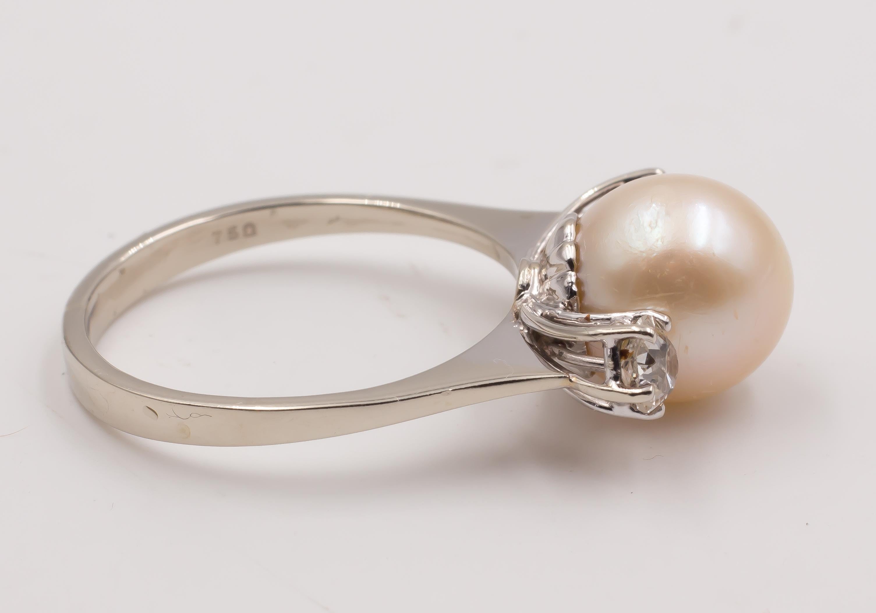 This simple but elegant ring is set with a central pearl, flanked on either by a 0.2ct ca. diamond. 
The ring is crafted in white gold throughout. 

MATERIALS
Gold, pearl and diamonds (totalling 0.4ct ca.)

RING SIZE
7¾ US (resizable)
