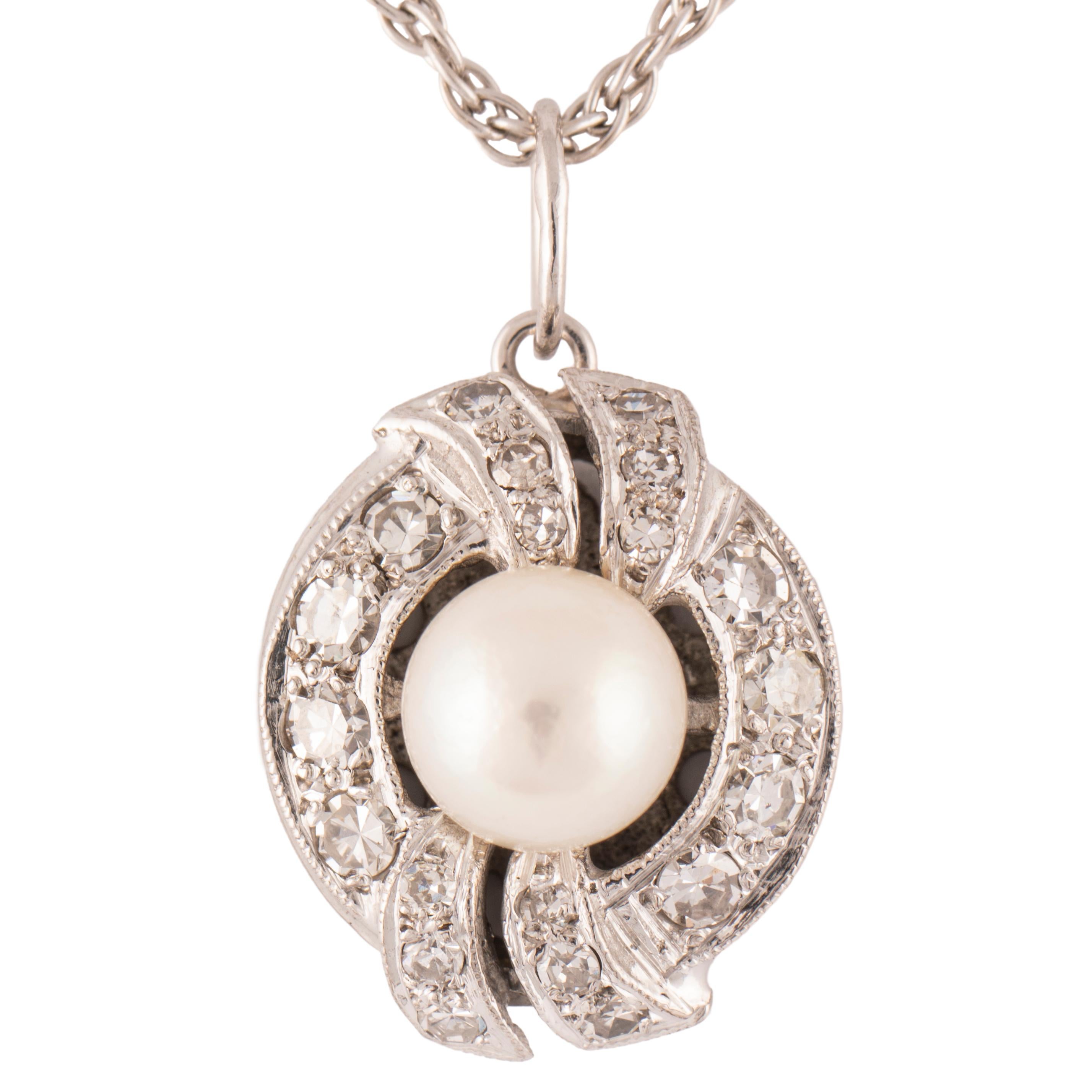 Beautiful cultured pearl and diamond pendant enhanced with scrolls on the top and bottom mounted in 14k white gold. The front is set with a lustrous pearl measuring approximately 6.4mm diam., surrounded by 20 round bright near colorless single cut