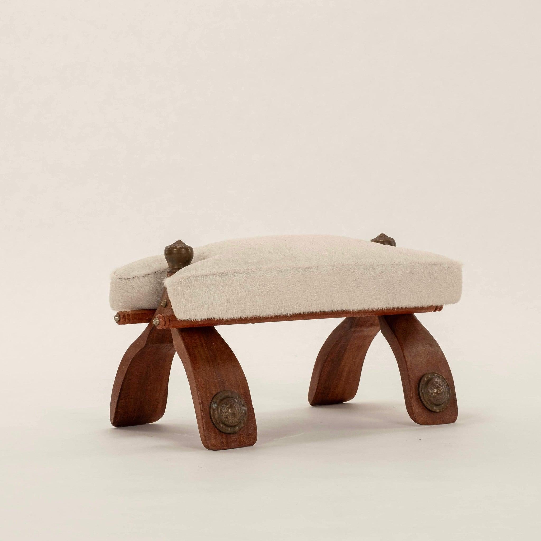 1940s Egyptian camel saddle stool: wood base with brass ormolu and newly upholstered white hair hide cushion.
