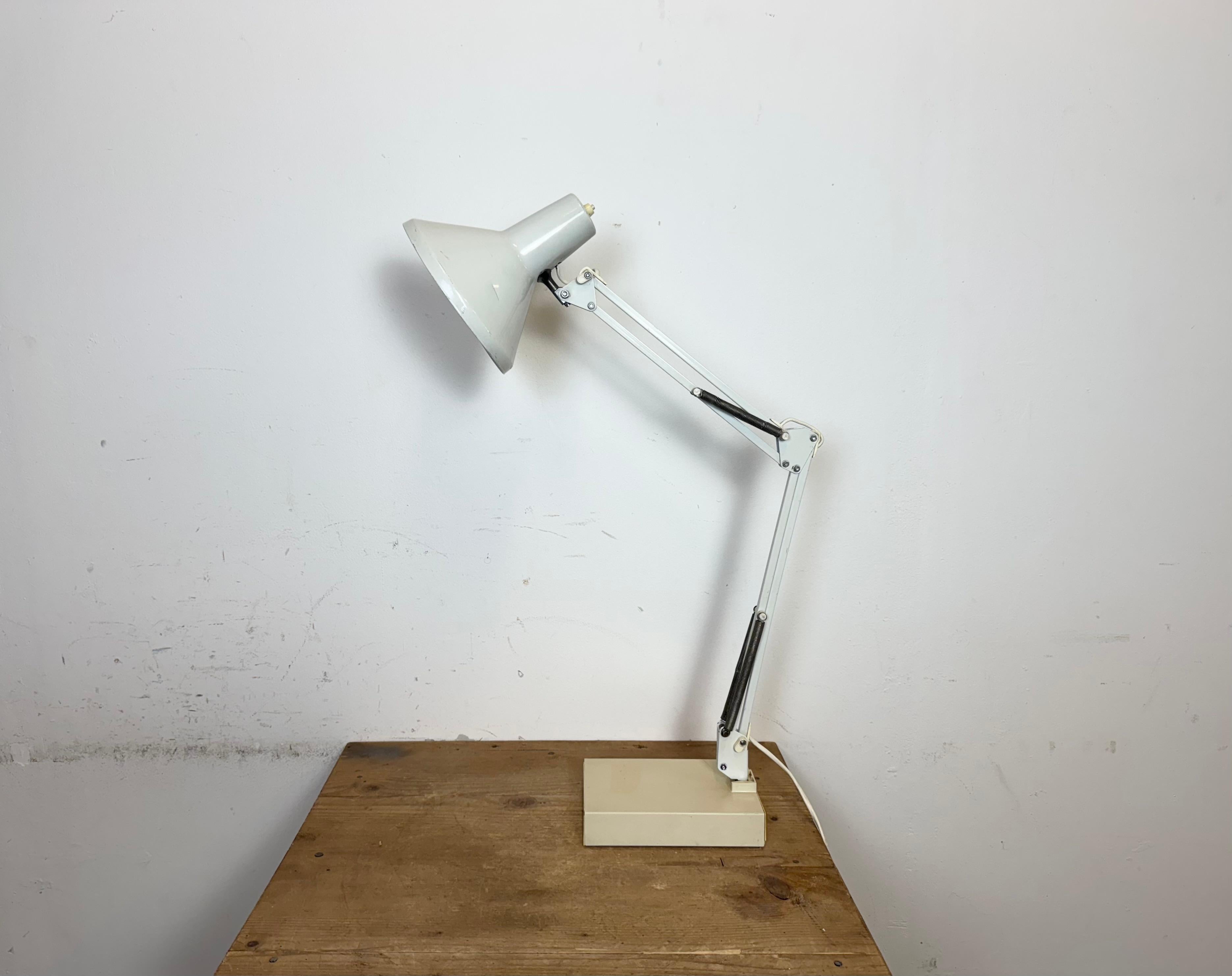 Lampada da tavolo regolabile bianca vintage realizzata in Italia negli anni '70. Regolabile in tutte le posizioni desiderate. Il paralume è in alluminio e il braccio e la base sono in ferro.  L'attacco in bachelite richiede lampadine standard E 27/