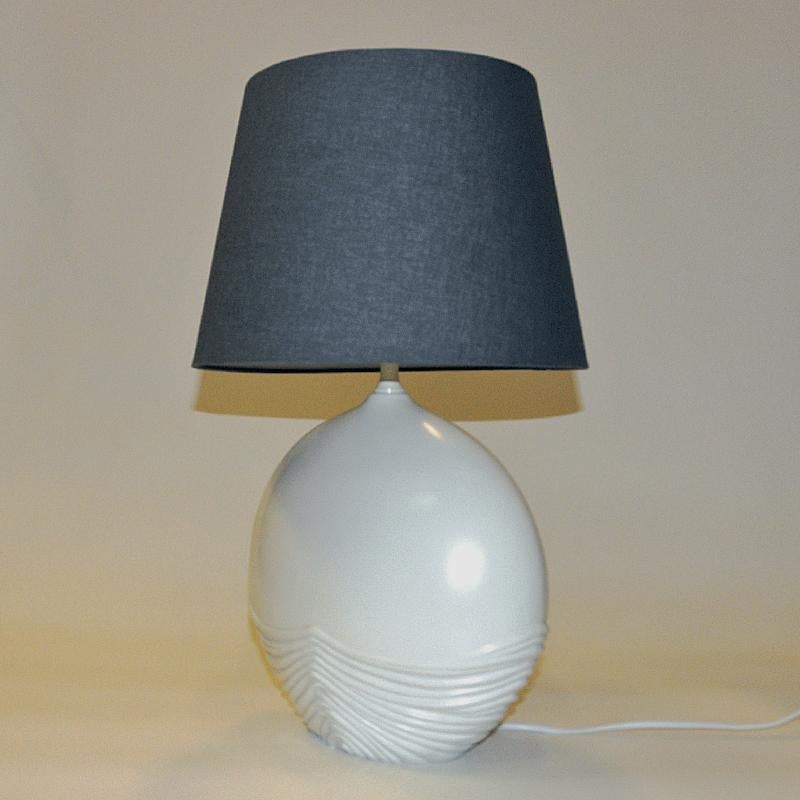 Lovely Italian ceramic table lamp - ovalshaped with relieff striped decor on the bottom of the lamp base. From Italy around the 1980s. Glazed white surface and marked underneath with Made in Italy and labeled 5427 Bianco mat. Lovely lamp for any