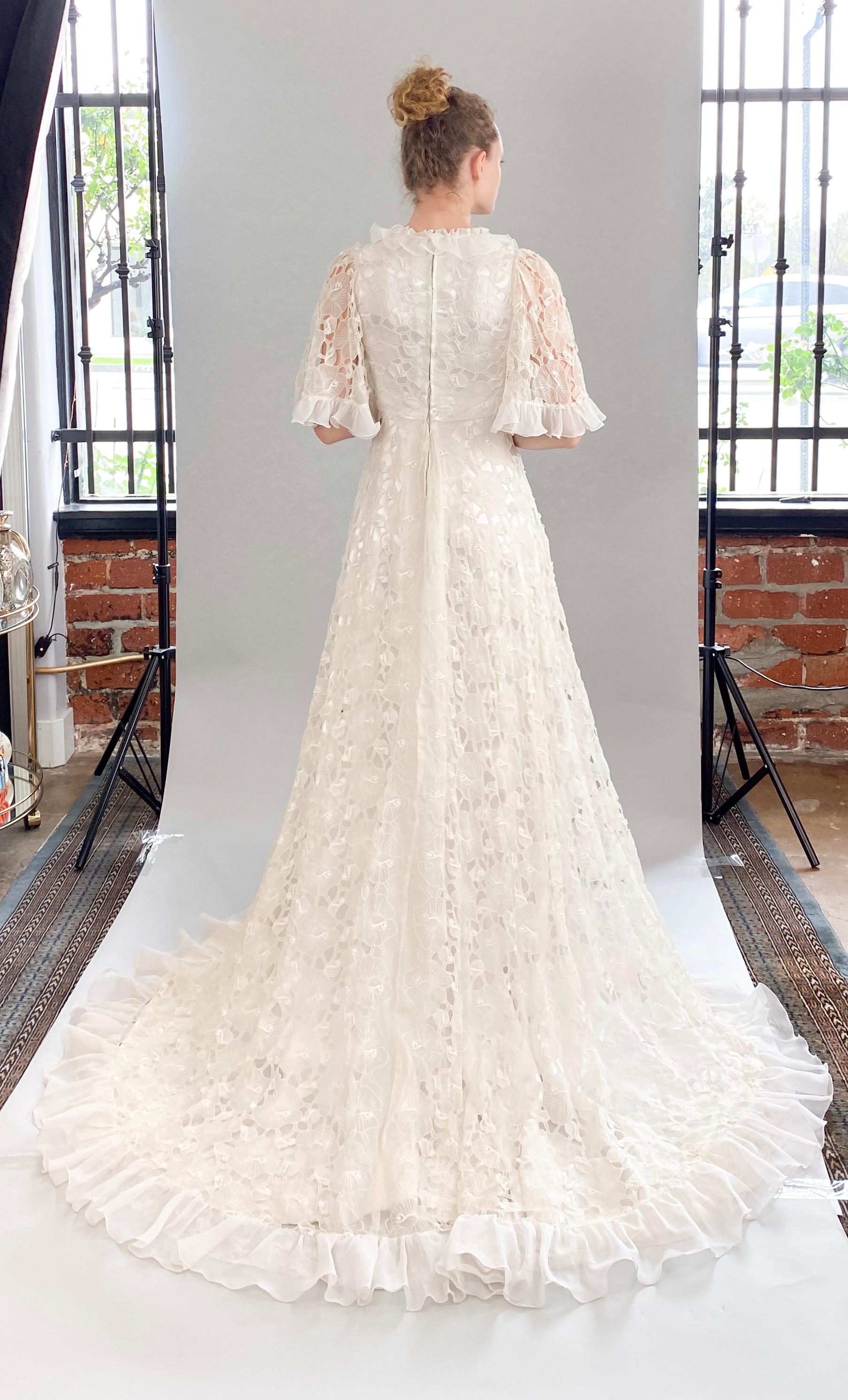 Indulge in sophistication and luxury with our White Lace Silk Ruffle Wedding Gown. Crafted with vintage white lace, ruffle sleeves and collar, and delicate silk chiffon trim, this high-low gown exudes elegance and timeless charm. Perfect for the