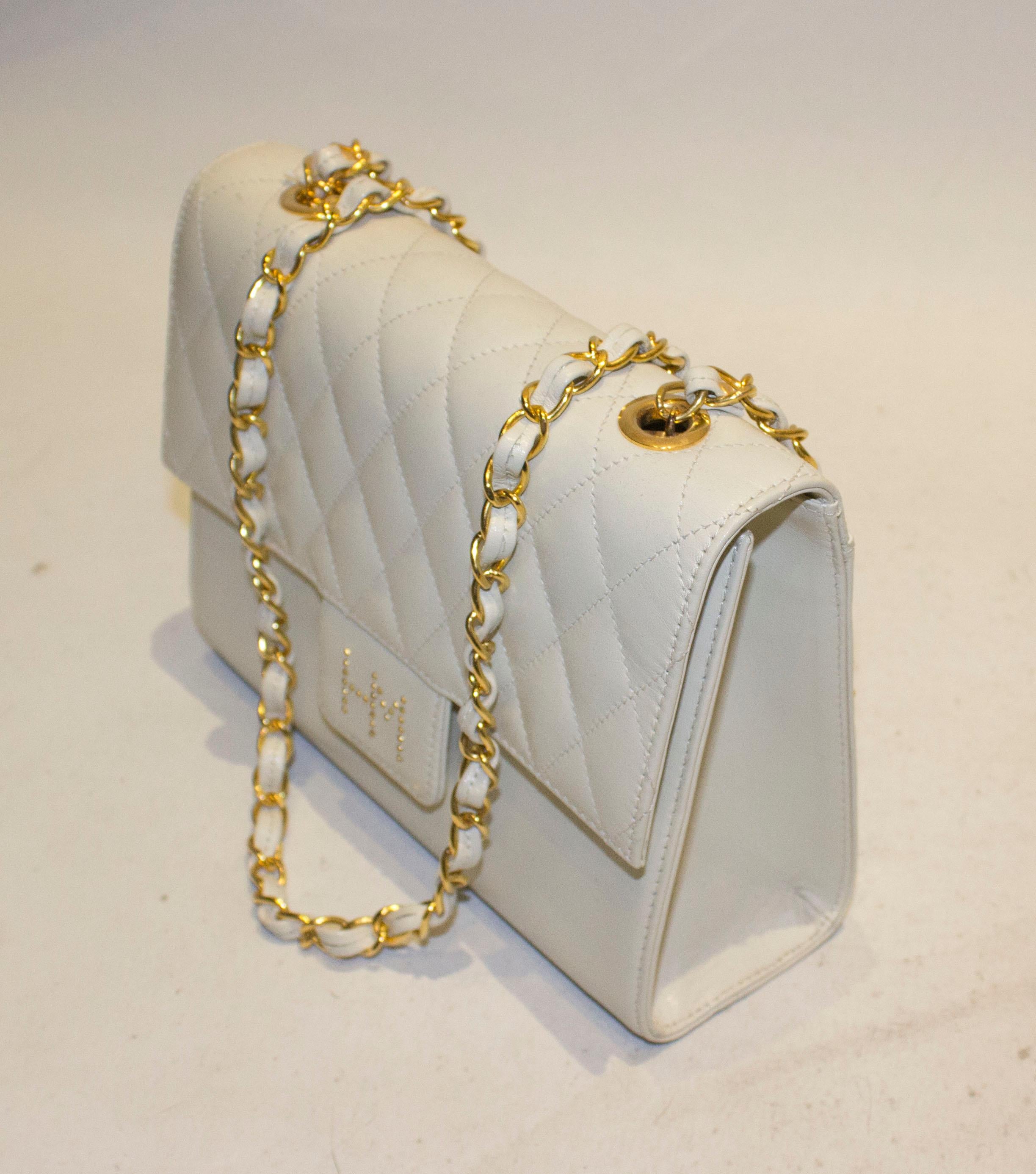 A chic vintage bag by Hanae Mori. The white leather bag has a quilted flap over front with popper fastening.  There is one internal pouch pocket and a pouch on the reverse, the bag has a 42'' chain handle. Measurements  width 8'', height 6'' , depth
