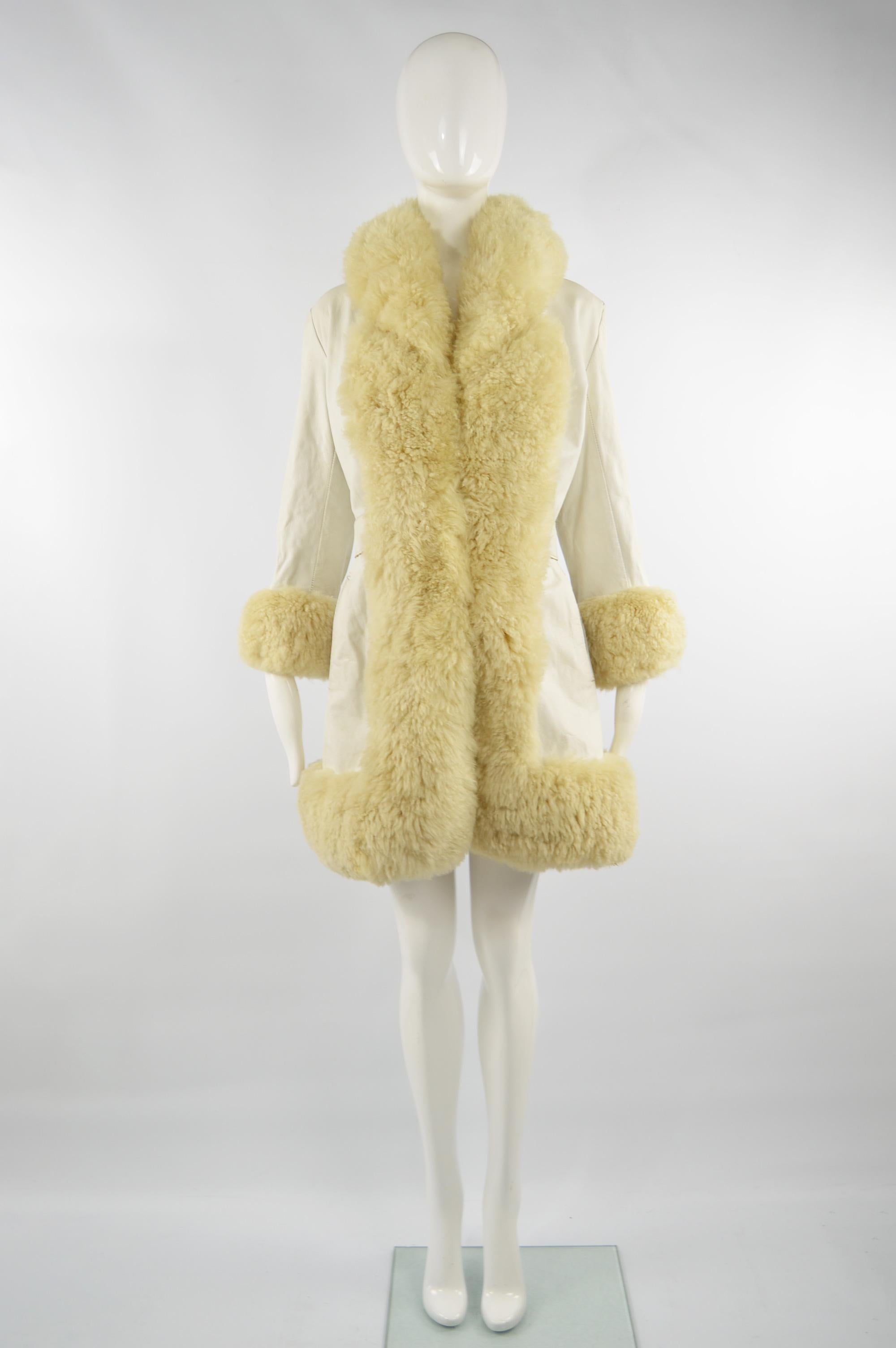 An absolutely amazing vintage bohemian afghan coat from the 60s in a white leather with an ultra glamorous shearling trim. Since the leather itself is lightweight and it is lined in a black satin, it is probably best suited to spring and autumn.