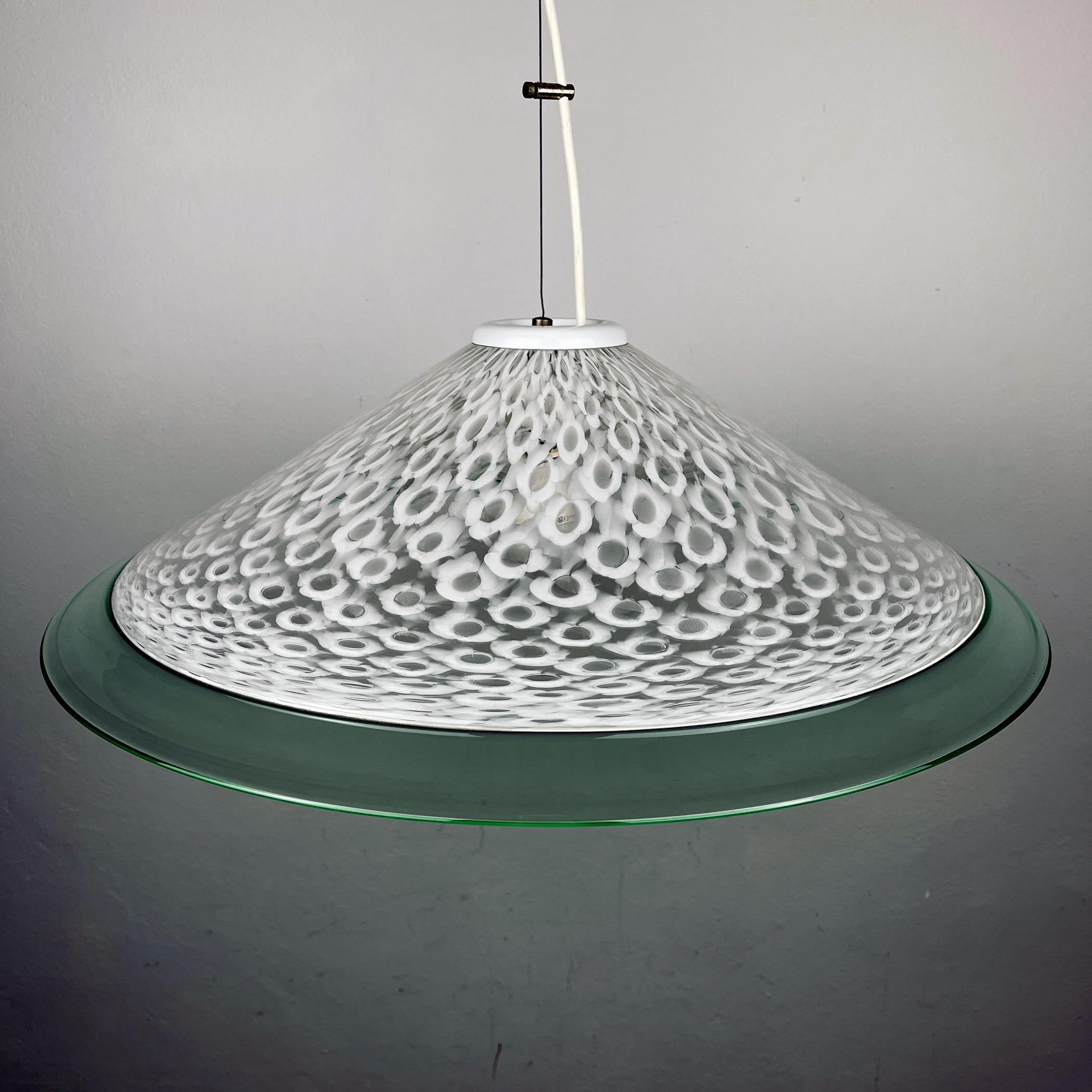 The stylish and elegant, this milky white and green Murano glass pendant lamp is a classic example of 70s Italian lighting. Made in Italy.
In excellent vintage condition. No chips or cracks. Maximum height with cable 95 cm. E27 bulb required. Lamp
