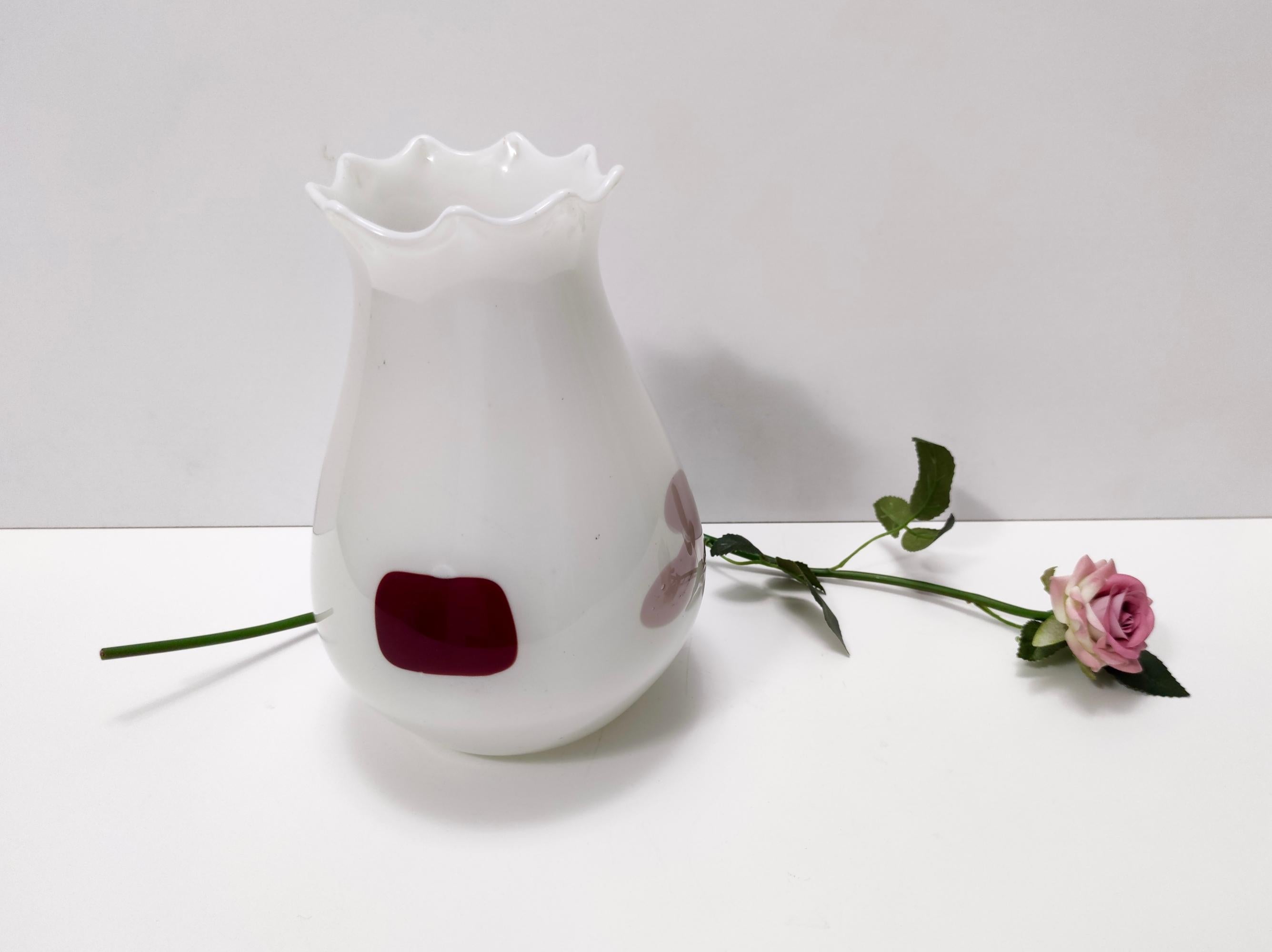 Fabriqué en Italie, années 1950. 
Ce vase blanc en verre de Murano l'attimo présente des inserts en verre coloré de couleurs de cartes à jouer (carreau, trèfle, cœur et pique).
Il s'agit d'une pièce vintage, elle peut donc présenter de légères