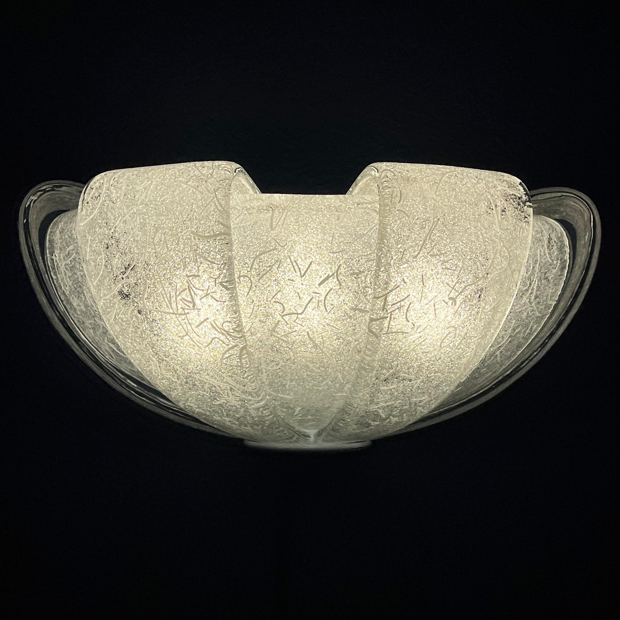 Vintage white Murano wall lamp with petals-shaped design, made in Italy in the 1980s. This Mid-Century Modern (MCM) Murano sconce features an elegant petals-like structure and accommodates three E14 bulbs.

It is in very good vintage condition,