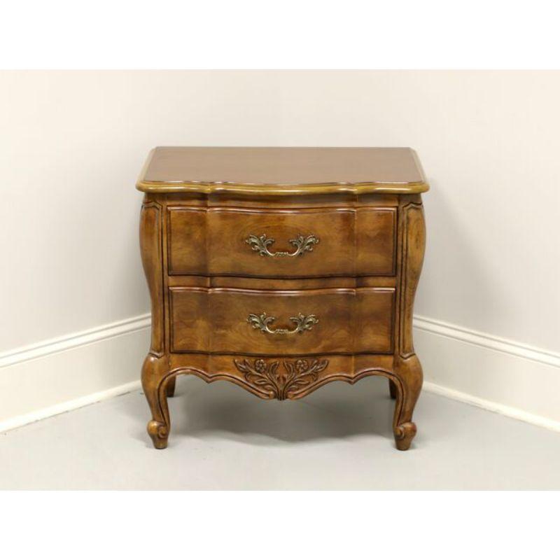 A French Country style nightstand by White Furniture, of Mebane, North Carolina, USA. Cherry with brass hardware, curved front, carved apron and scroll feet. Features two drawers of dovetail construction. Made in the late 20th Century.

Measures: