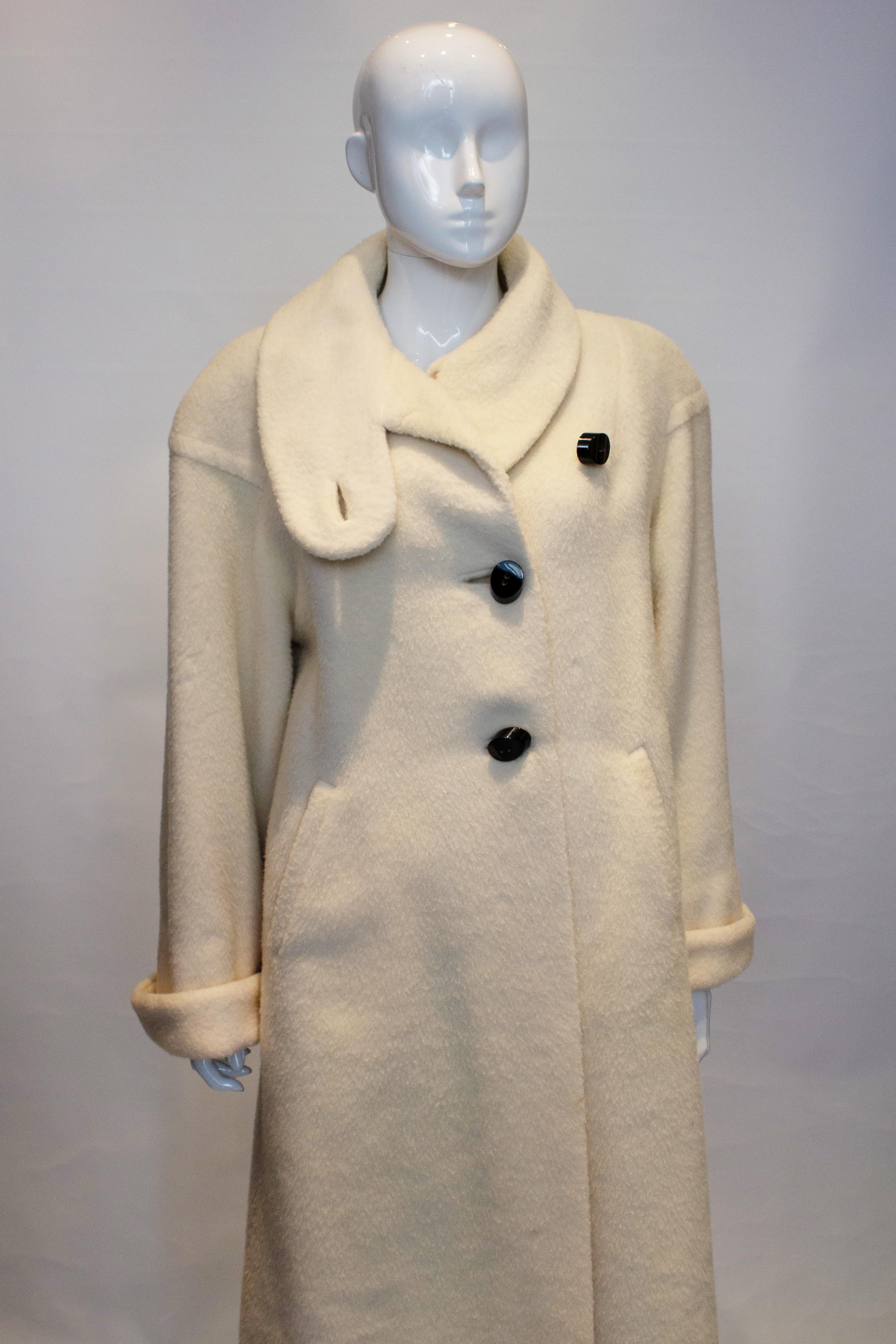 A wonderful vintage white coat with wonderful oversize buttons. The coat has a stand up collar, pockets on either side and turn back cuffs. It is fully lined.
Measurements bust up to 46'', length 48''
