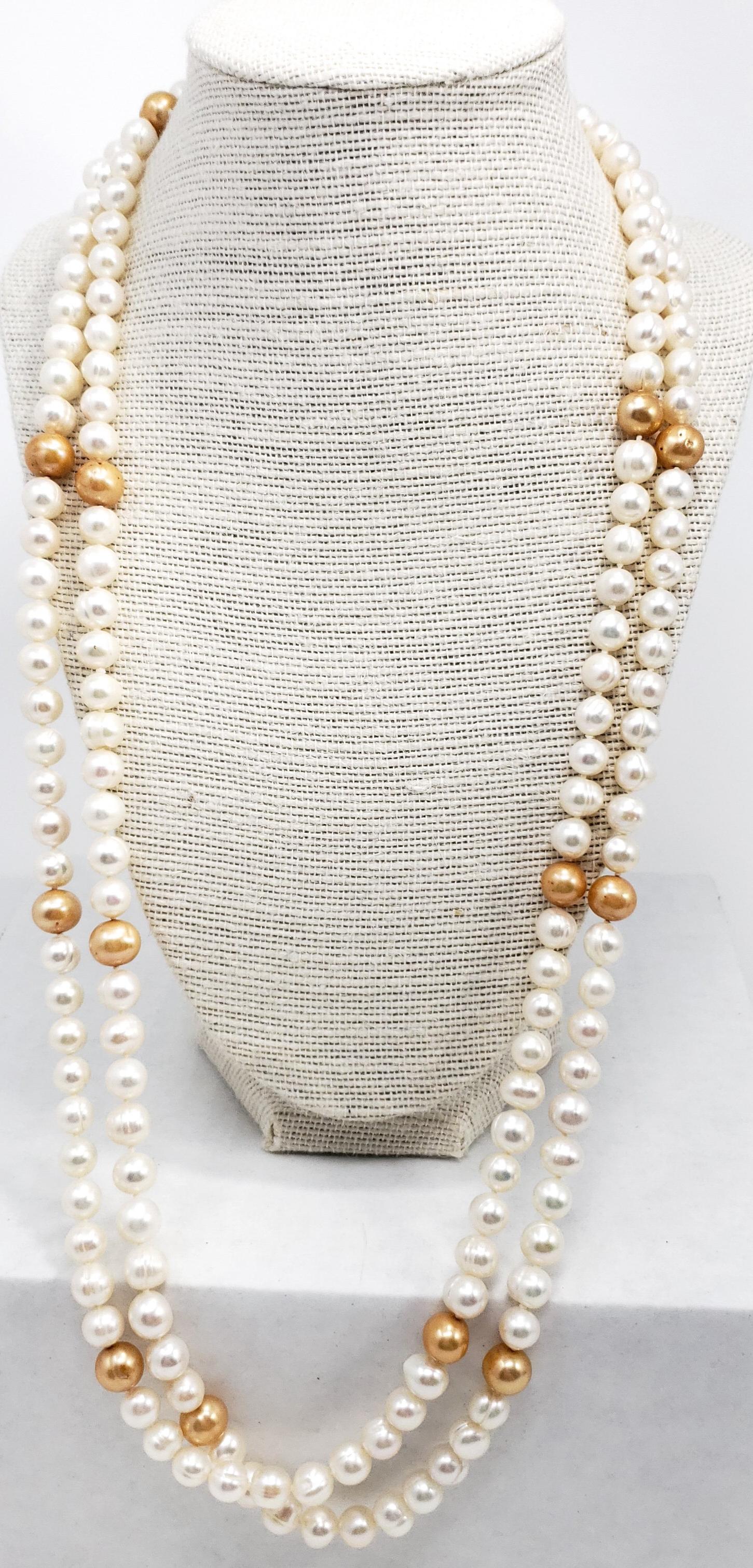 Vintage pearl necklace, featuring a single, 56 inch strand of white and peach pearls. An exquisite accessory!