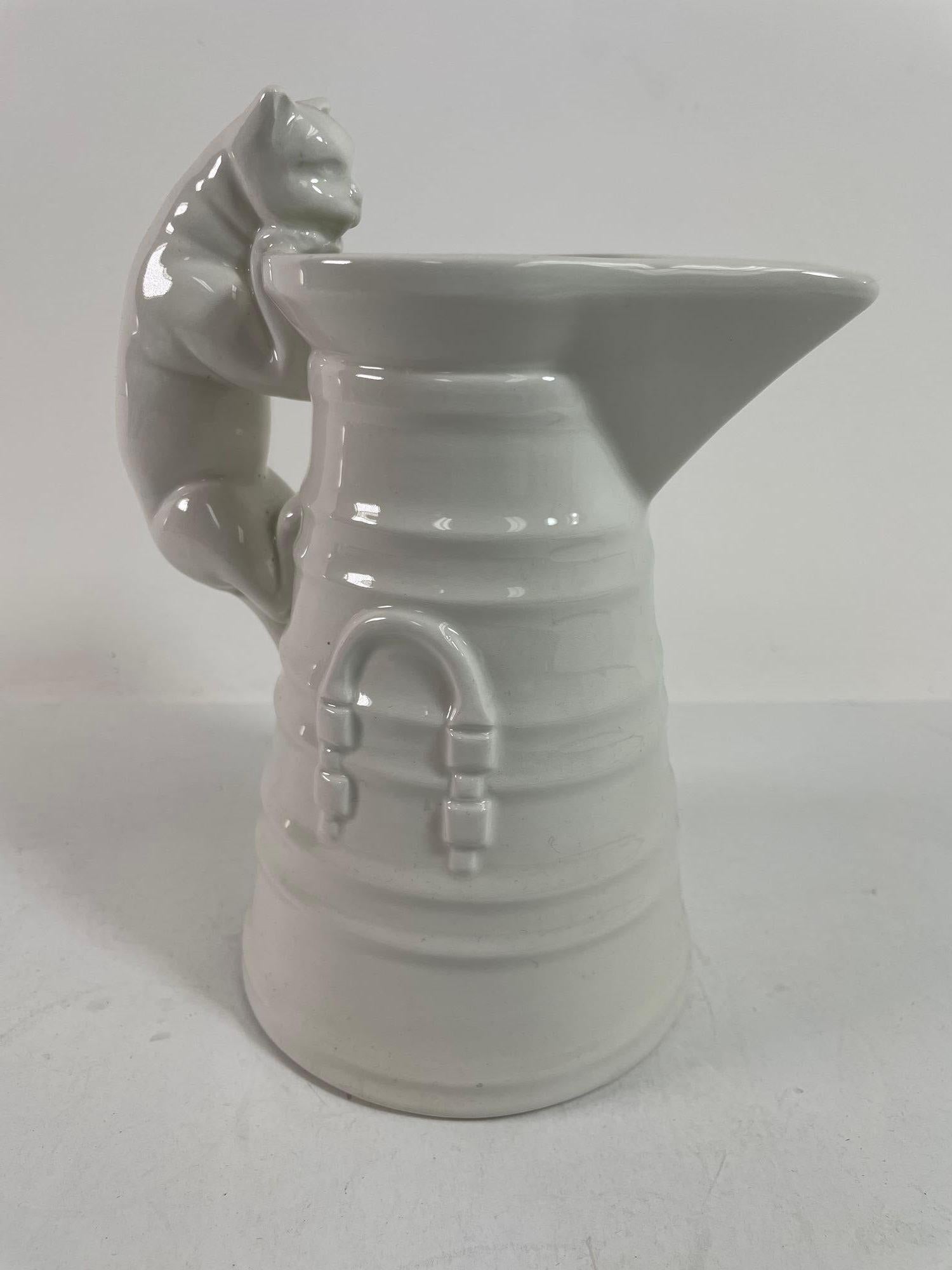 Vintage White Porcelain Cat Pitcher Made in Italy.
Mid 20th Century white cat that got the cream jug.
Victorian style jug of a cat looking over the edge of milk churn.
Made after the Victorian English Spode Copeland cream milk jug with cat handle,