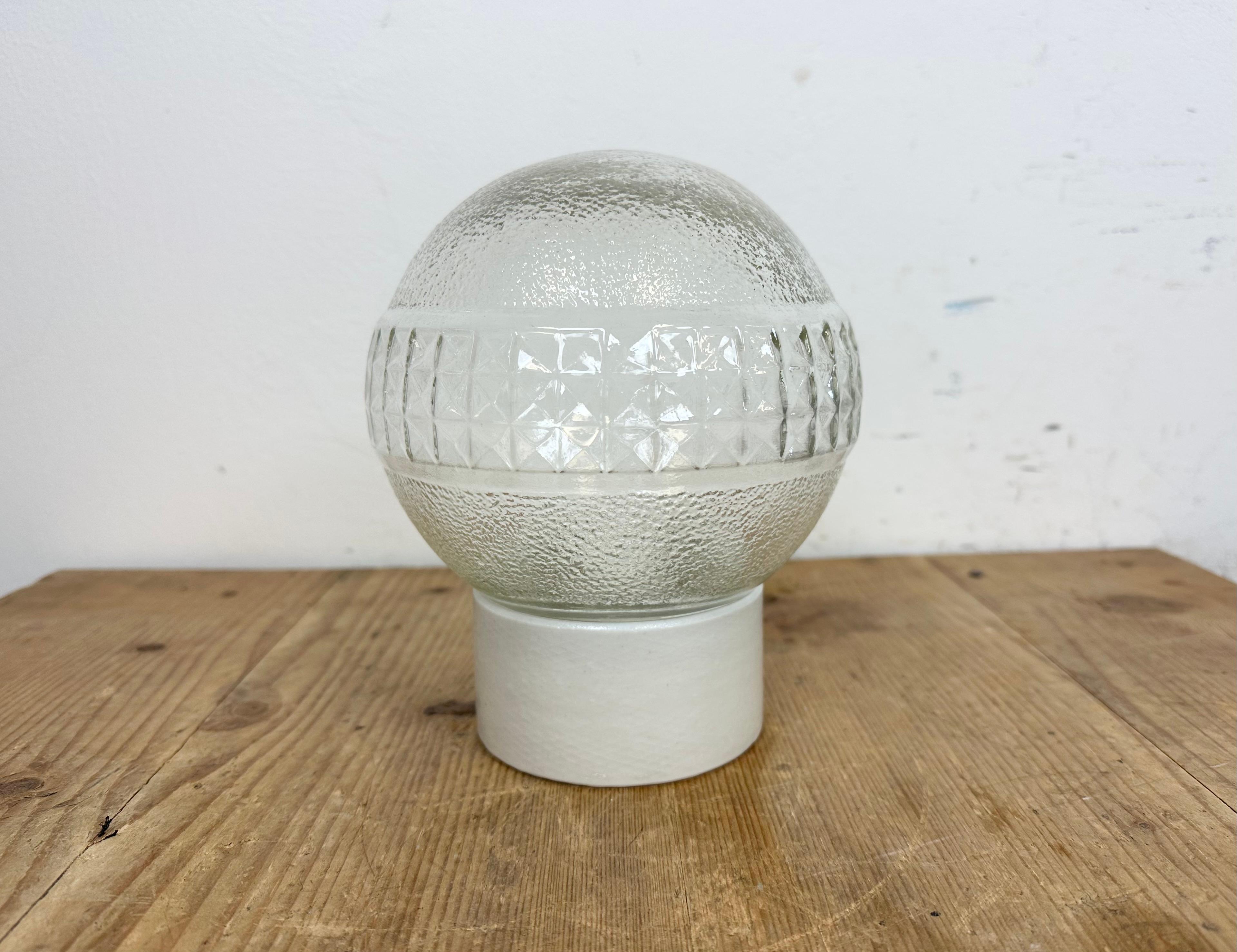 Vintage industrial ceiling or wall light  made in Poland during the 1970s. It features a white porcelain wall mounting and a glass cover. The socket requires E27/E 26 light bulbs. New wire. The weight of the lamp is 0,9 kg.
Dimensions: 
Diameter of