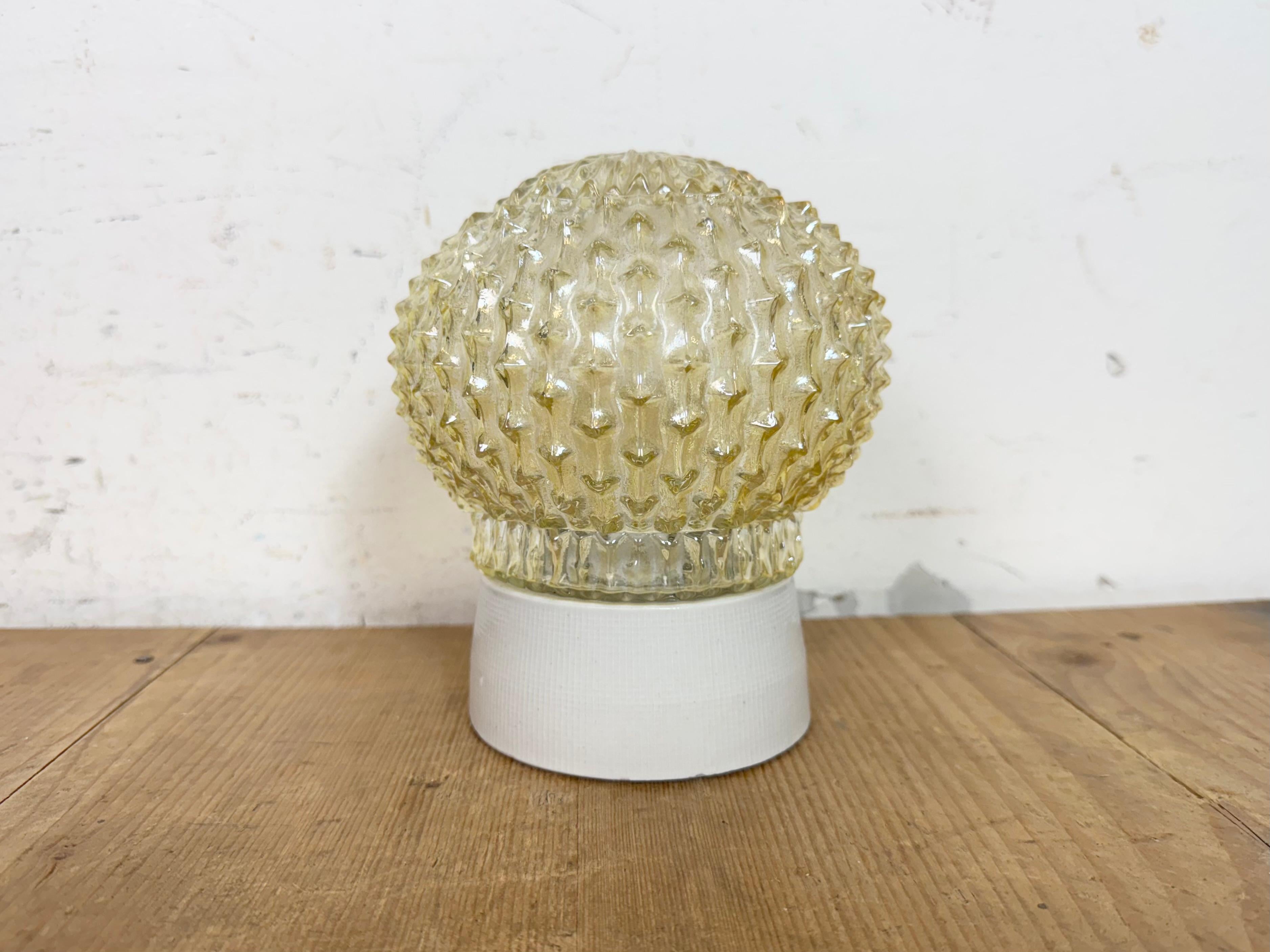 Vintage industrial ceiling or wall light  made in former Czechoslovakia during the 1970s. It features a white porcelain wall or ceiling mounting and a glass cover. The socket requires E27/E 26 light bulbs. New wire. The weight of the lamp is 1