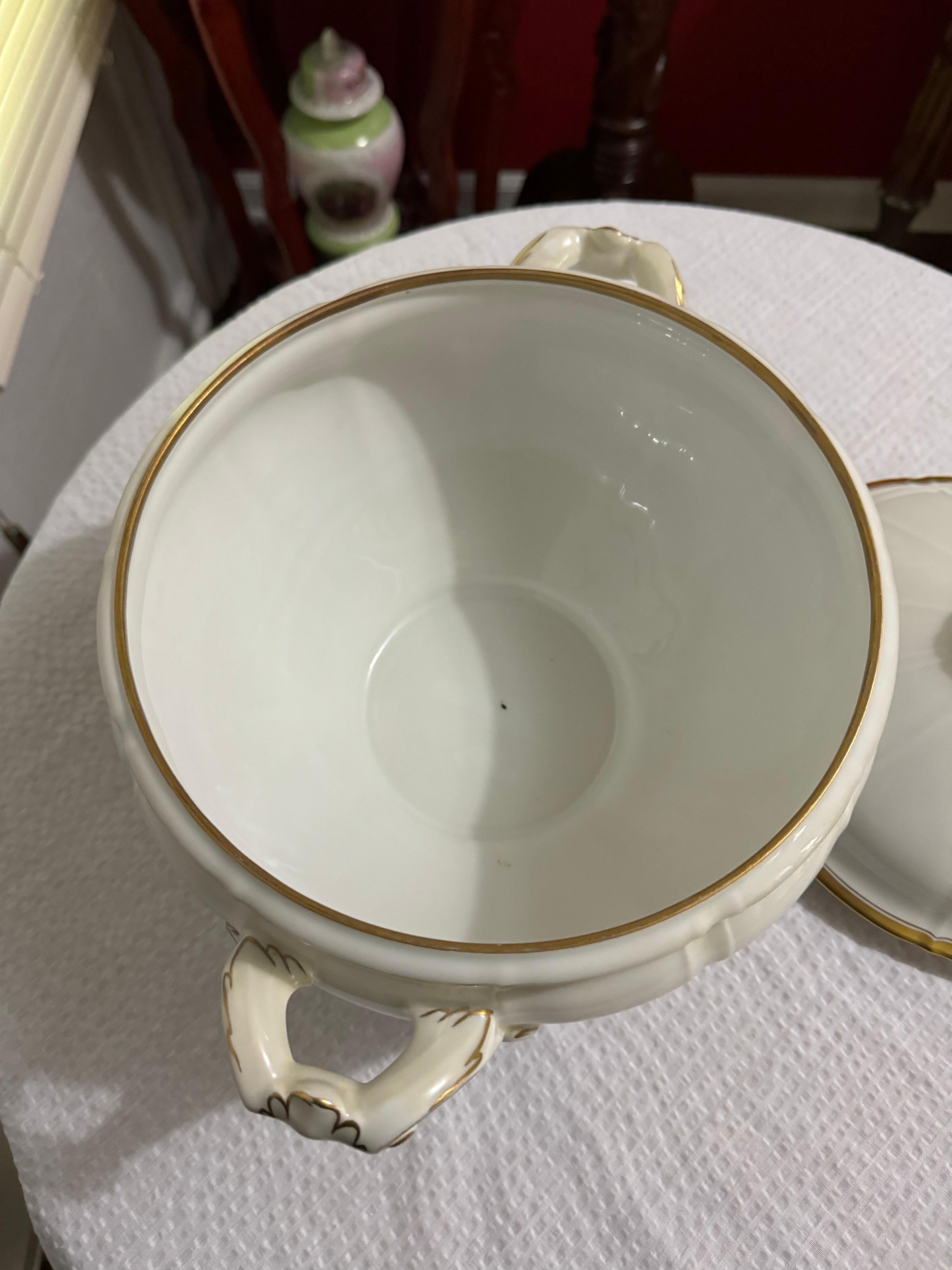 Grande zuppiera a piede in porcellana bianca con corpo a pannelli, finiture dorate e finalino floreale in rilievo.
Non usato, quasi nuovo. Alto circa 12'' fino al terminale del coperchio e largo 13,5'' da manico a manico.
Largo 9,25''