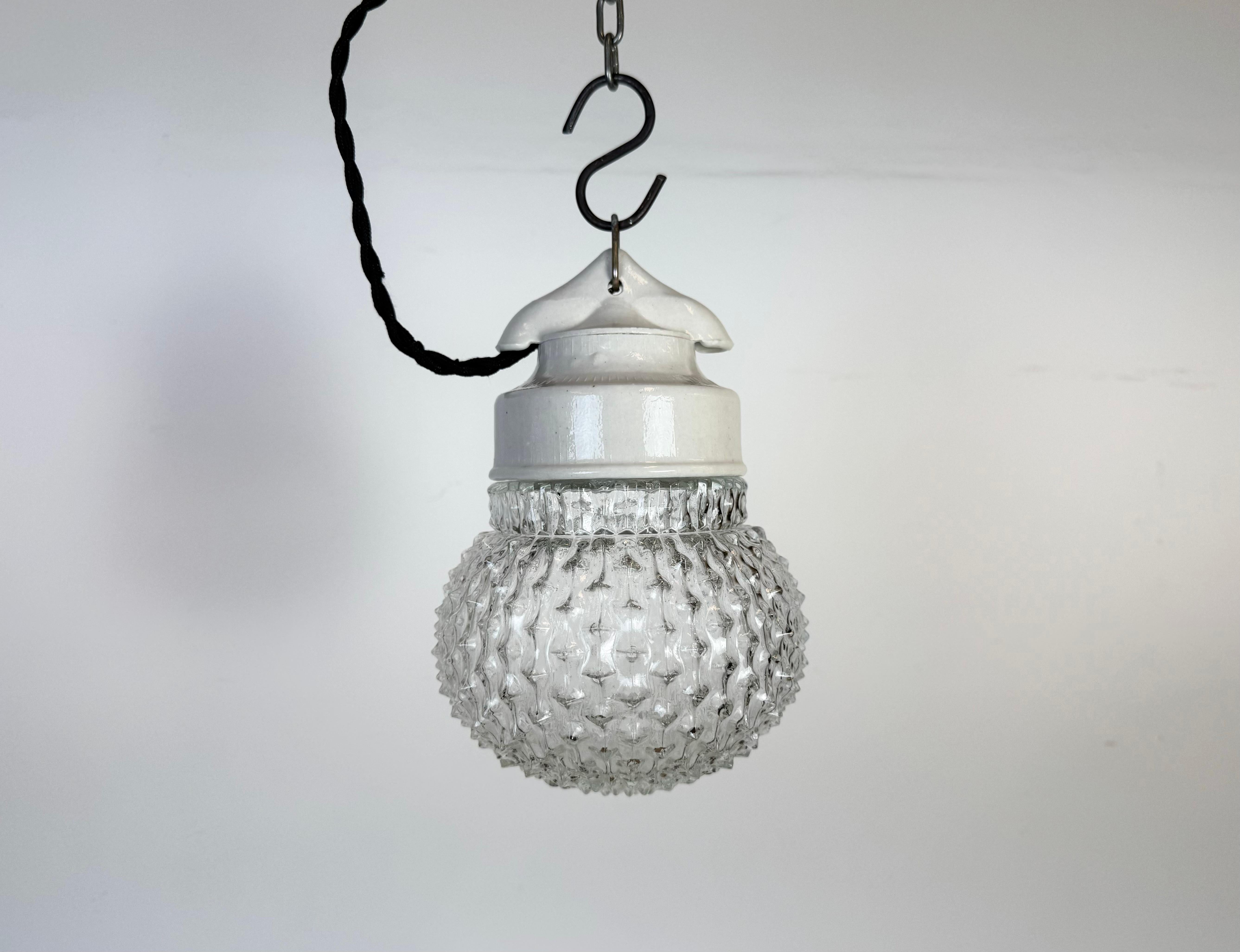 Lampada industriale vintage prodotta nell'ex Cecoslovacchia  durante gli anni '70. Presenta un piano in porcellana bianca e un coperchio in vetro. L'attacco richiede lampadine standard E27/ E26. Un nuovo cavo. Il peso della lampada è di 1