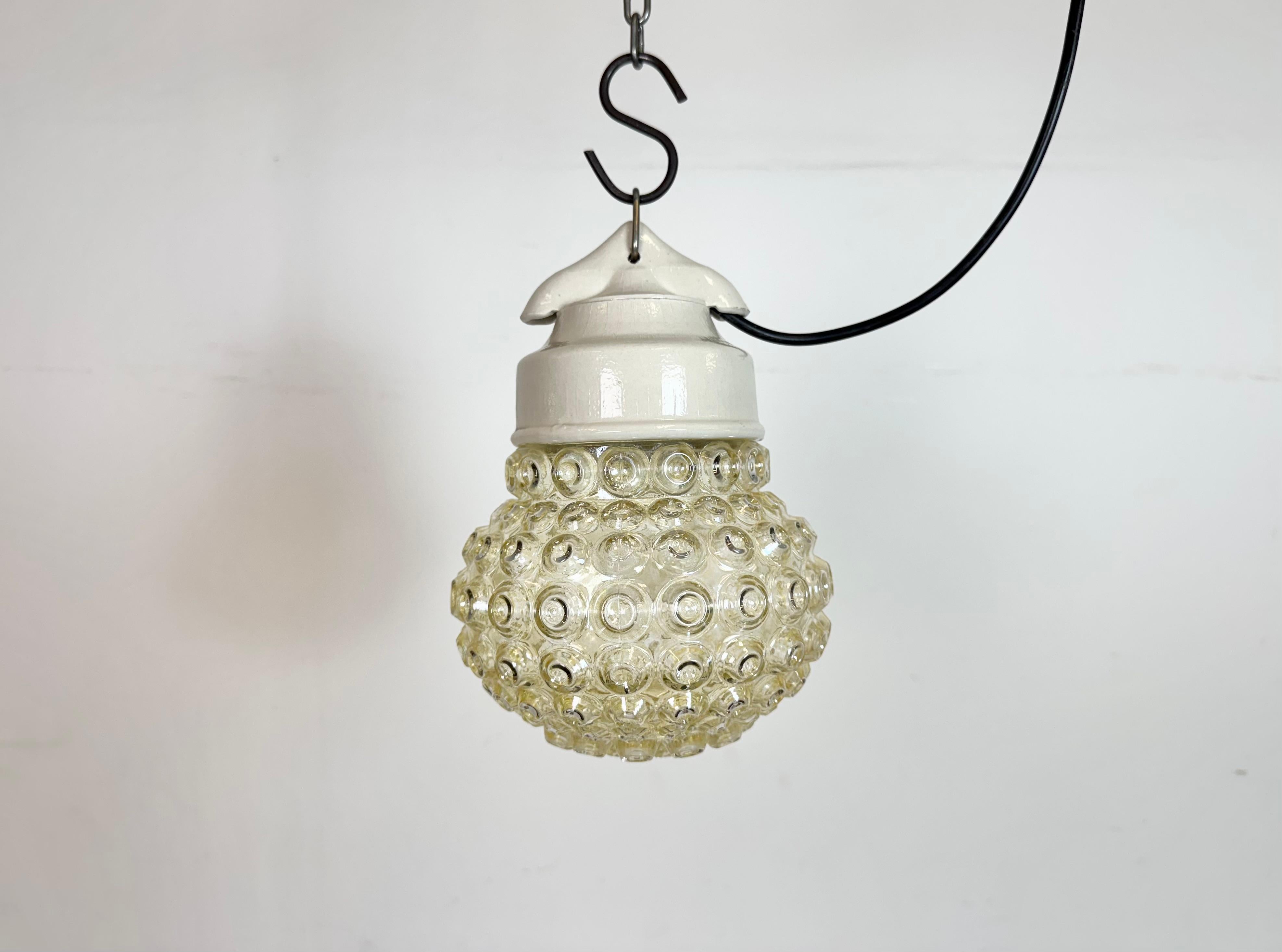 Lampada industriale vintage prodotta nell'ex Cecoslovacchia  durante gli anni '70. Presenta un piano in porcellana bianca e un coperchio in vetro. L'attacco richiede lampadine standard E27/ E26. Un nuovo cavo. Il peso della lampada è di 1