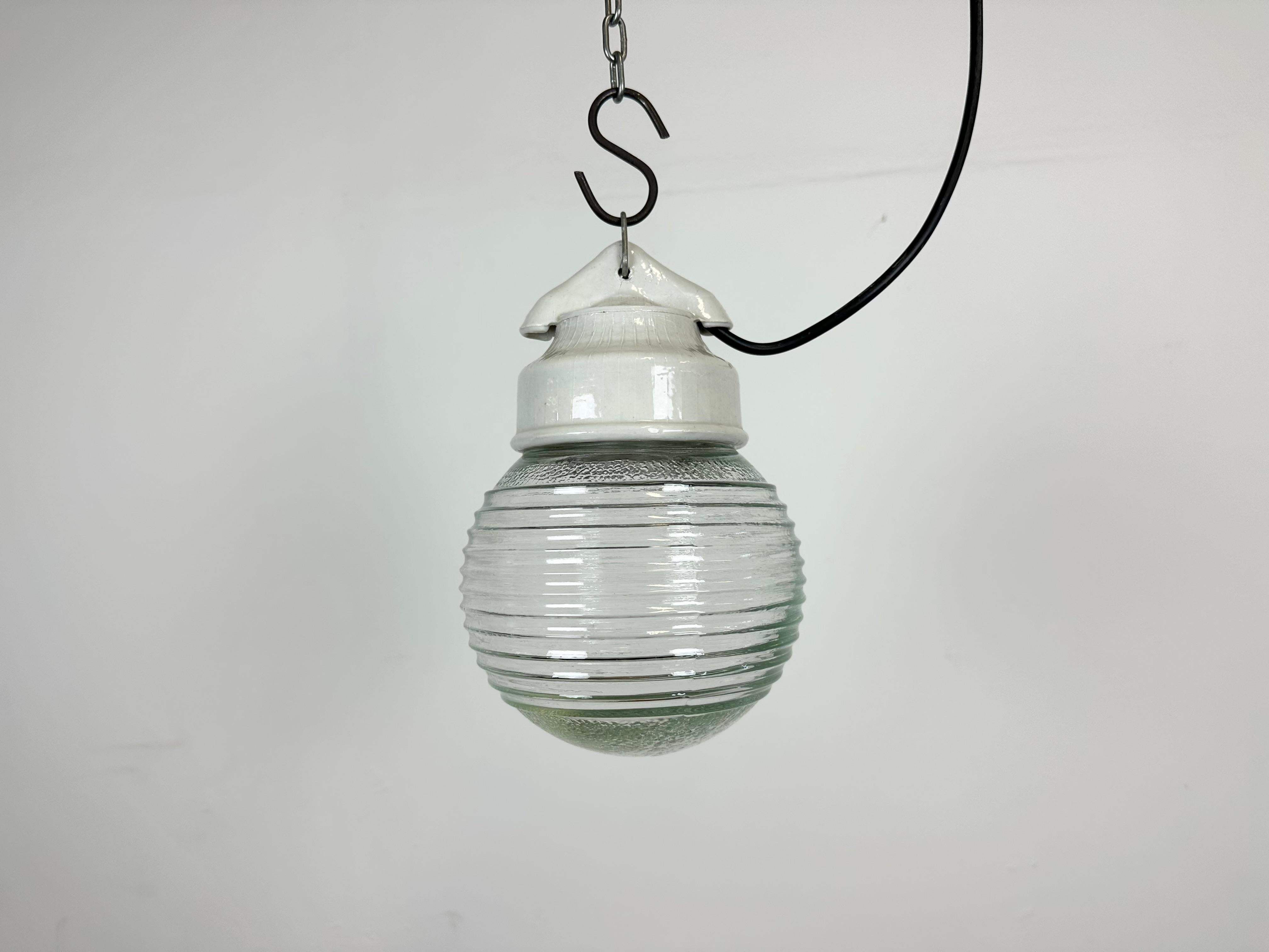 Vintage industrial light made in Poland during the 1970s.It features a white porcelain top and a ribbed glass cover. The socket requires E27/ E26 light bulbs. New wire. The weight of the light is 1 kg.