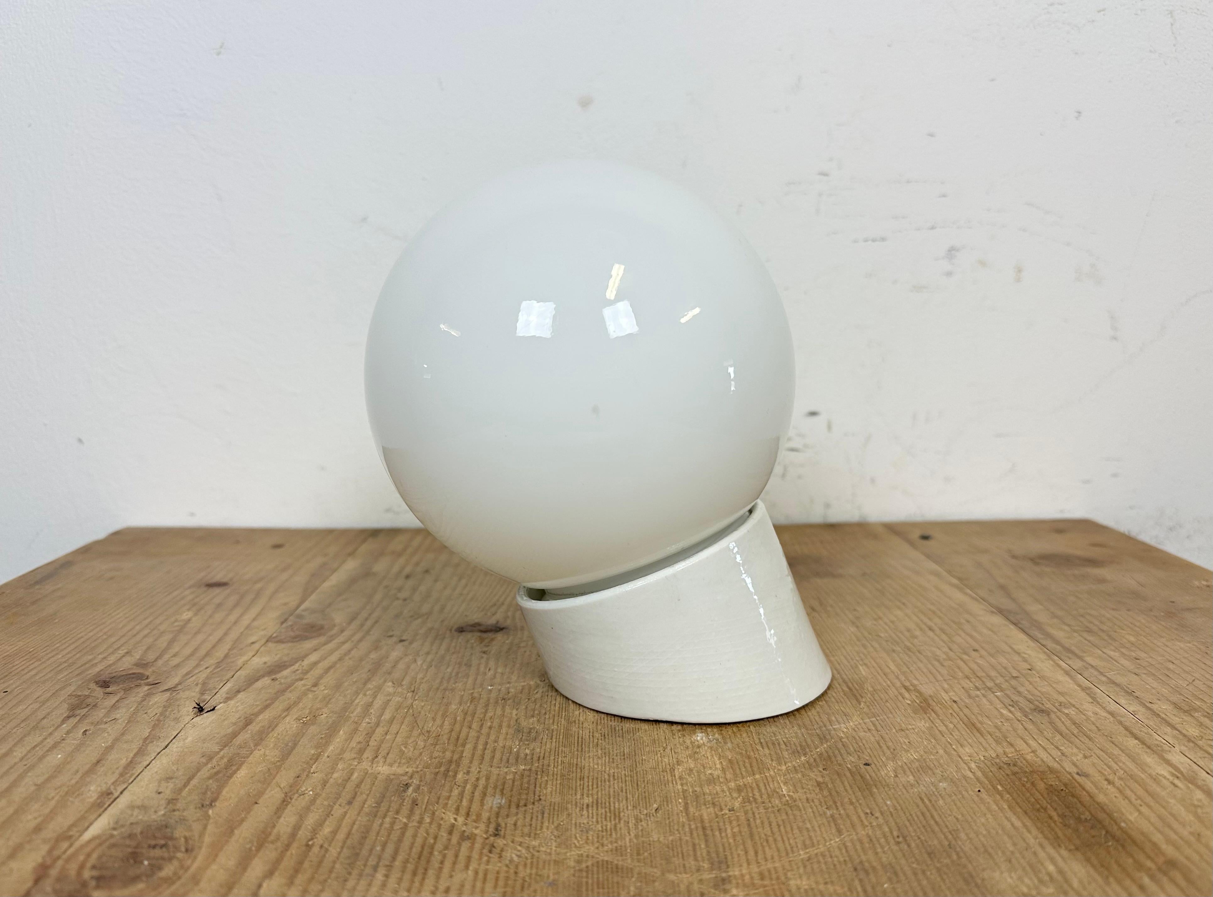 Vintage industrial light made in former Czechoslovakia the 1970s. It features a white porcelain wall mounting and a milk glass cover. The socket requires standard E27/E 26 light bulbs. New wire. The weight of the lamp is 1 kg.
Dimensions: 
Diameter