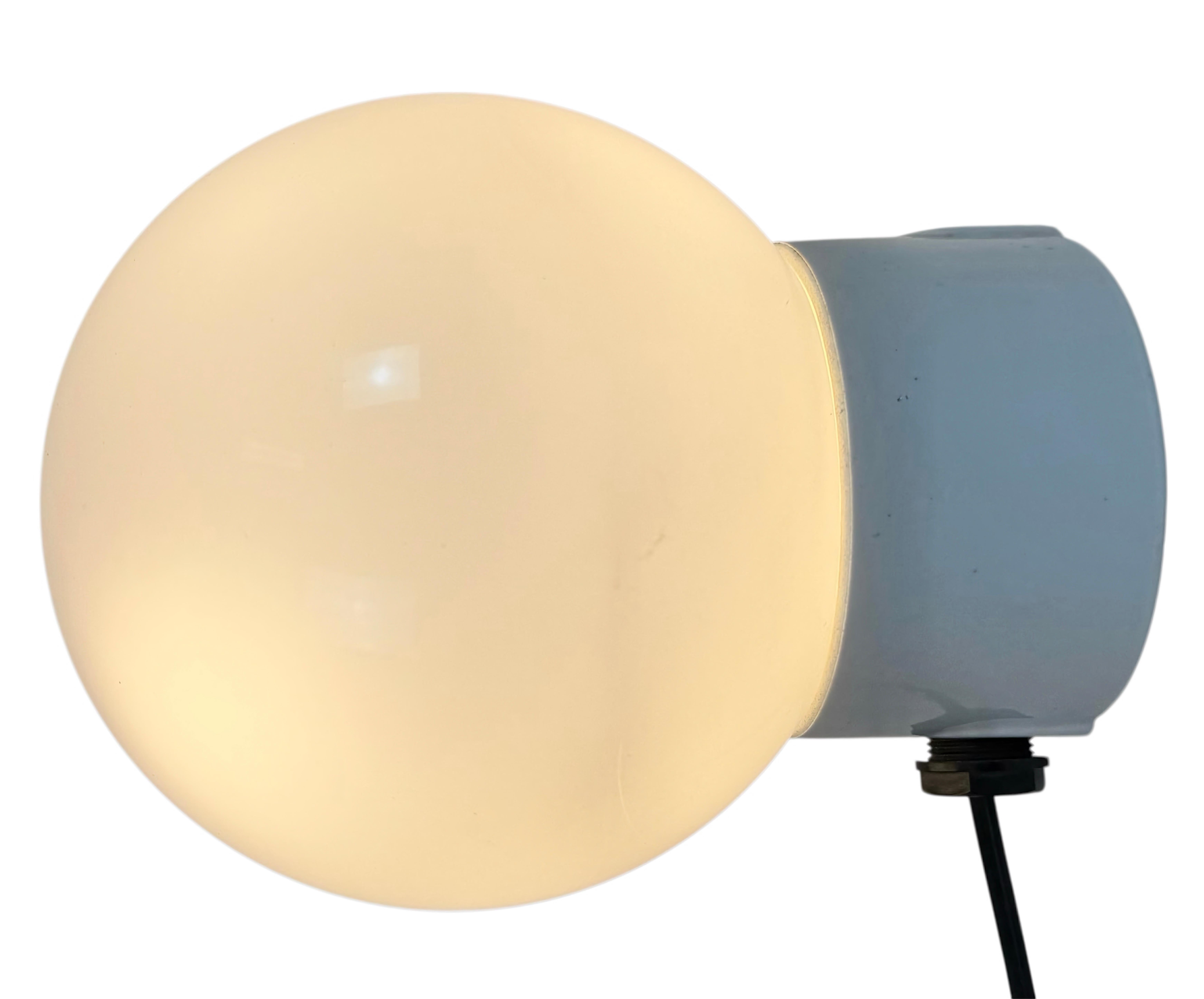 Lampada industriale vintage realizzata nell'ex Cecoslovacchia negli anni '1960. È dotato di un supporto da parete in porcellana bianca e di un coperchio in vetro latte. L'attacco richiede lampadine E27/E 26 standard. Un nuovo cavo. Il peso della