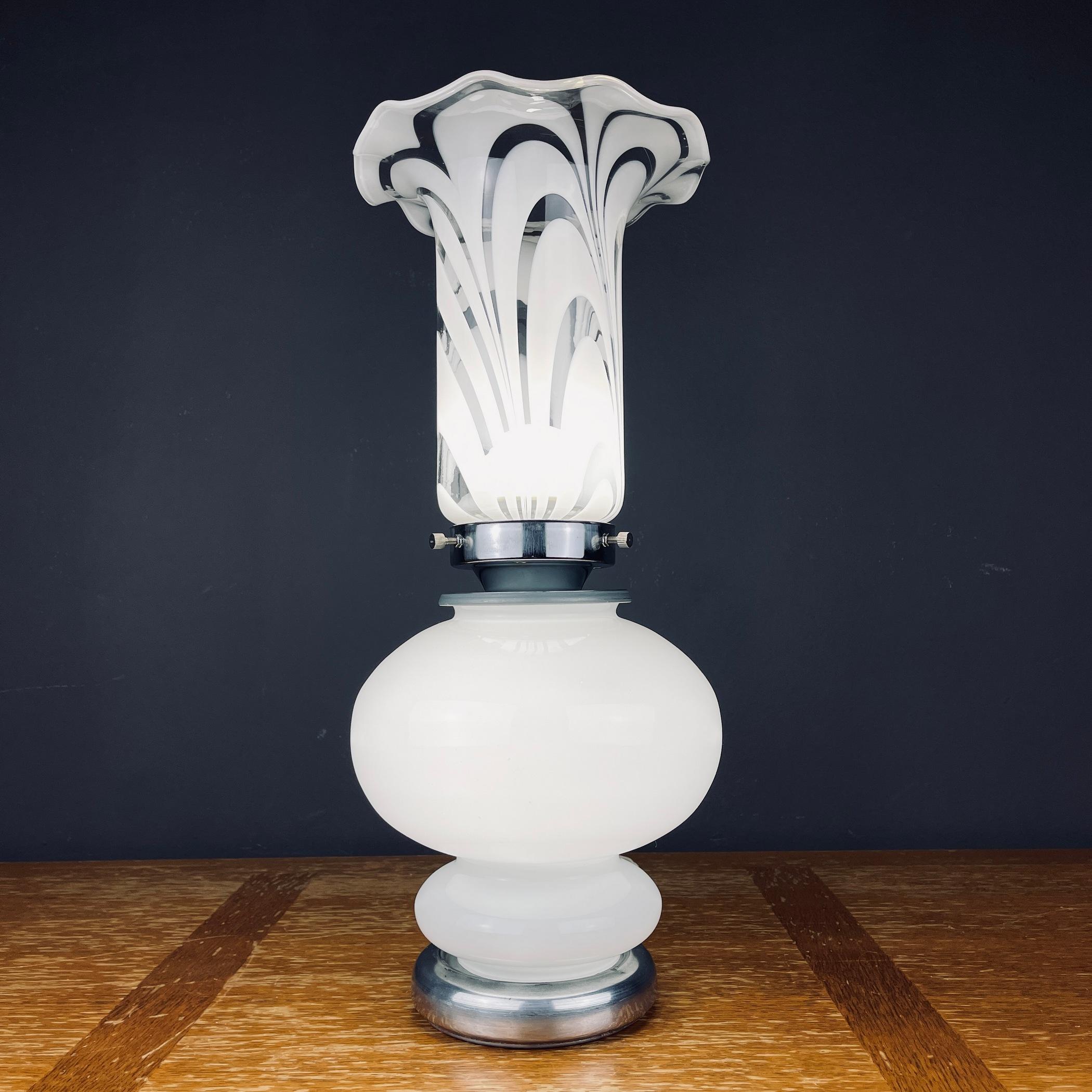 The vintage white glass table lamp was made in Italy in the 1980s. Retro lamp will bring to your home the atmosphere of 70s Italy. A mid-century table lamp will look great in an Art Deco or Mid-Century Modern interior. The lamp is suited for a