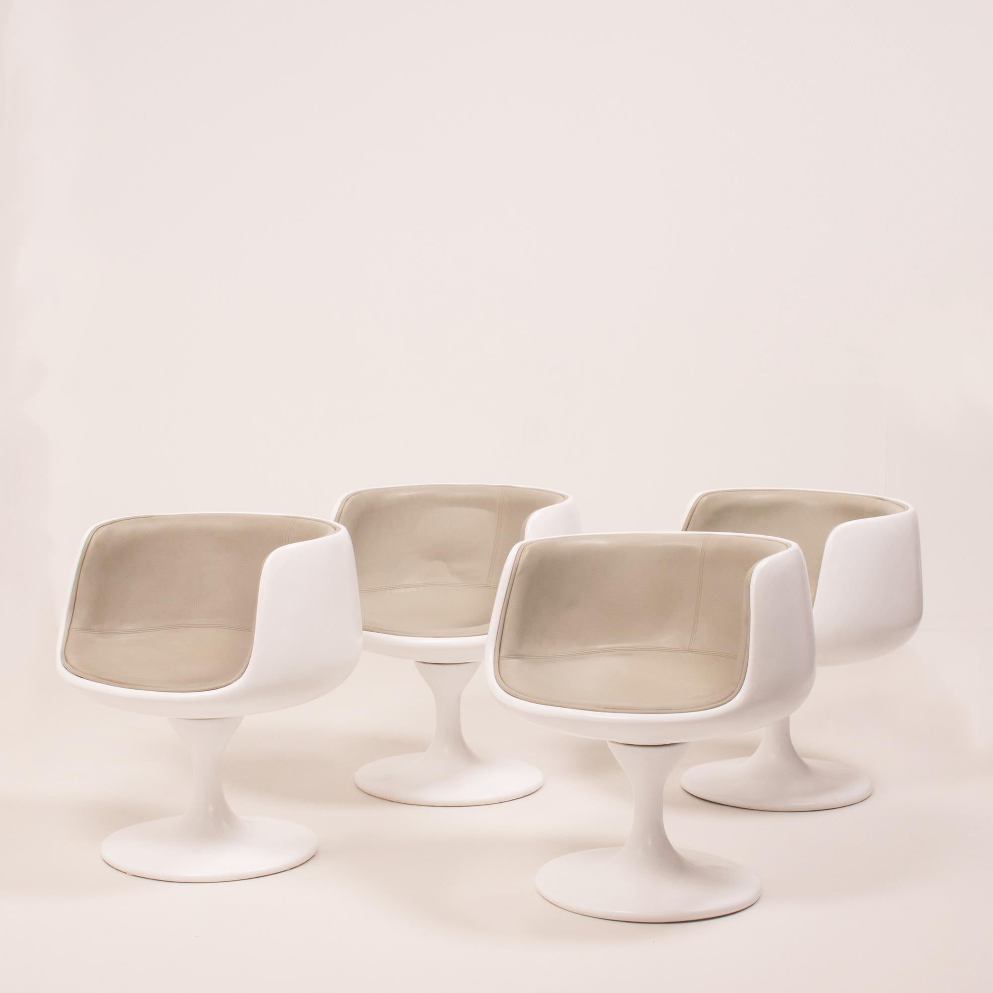 This set of four modern curved swivel tulip tub chairs have a sleek, modernist aesthetic and feature the iconic ‘tulip’ style base originally designed by Eero Saarinen. 

The chairs have moulded curved white shells, which have been newly lacquered,