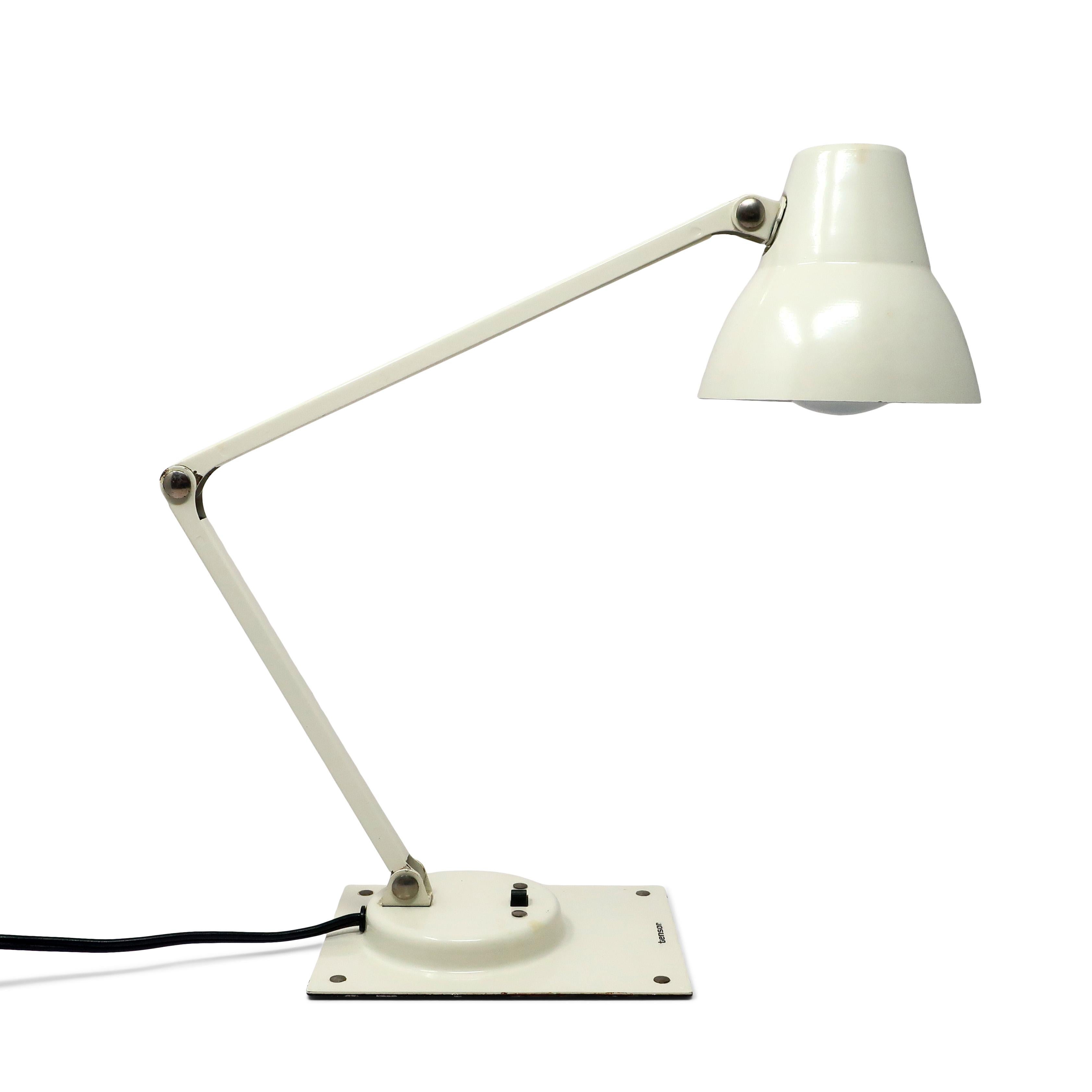 A perfect Mid-Century Modern Tensor articulating desk lamp. White metal base, shade, and stem, with on/off switch on the base. In good vintage condition with wear consistent with age and use.

Measures: 4” x 8.5” x 14”, extends to 20” tall.