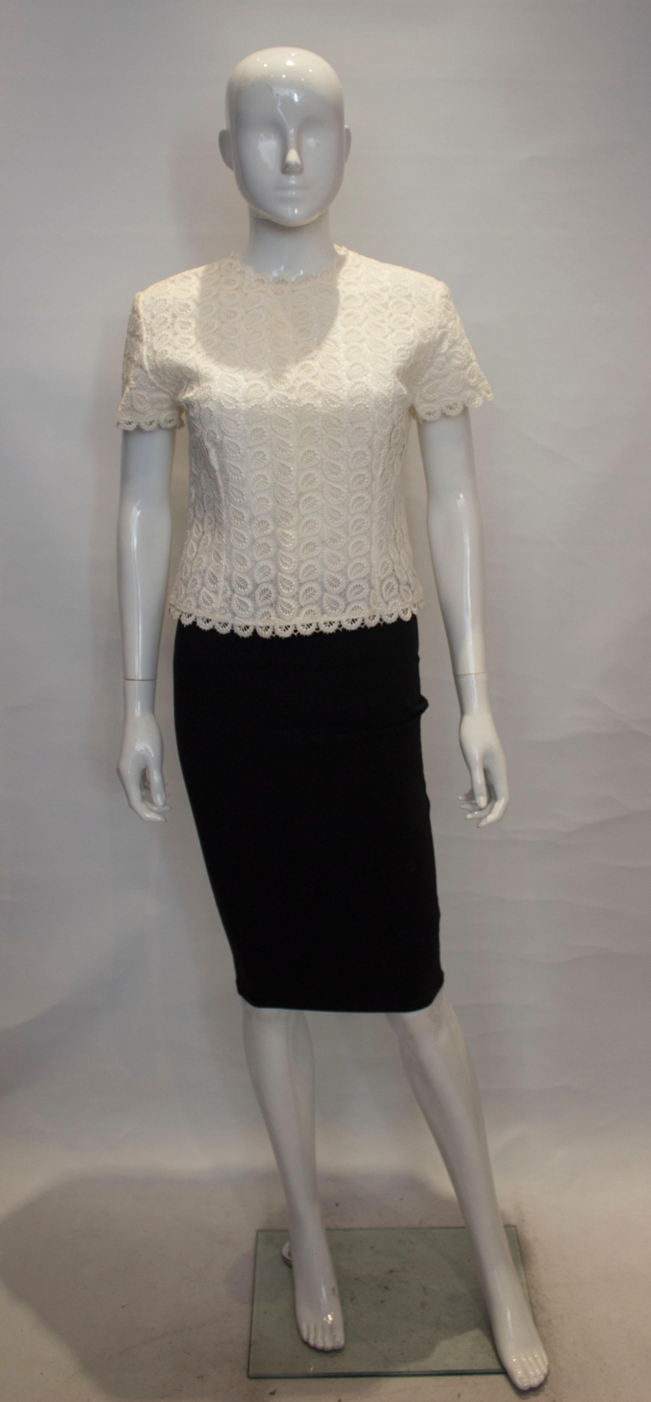 A pretty vintage white top, by Demore of Mayfair The top has short sleaves, lace edging and a button opening at the back.  It is fully lined.