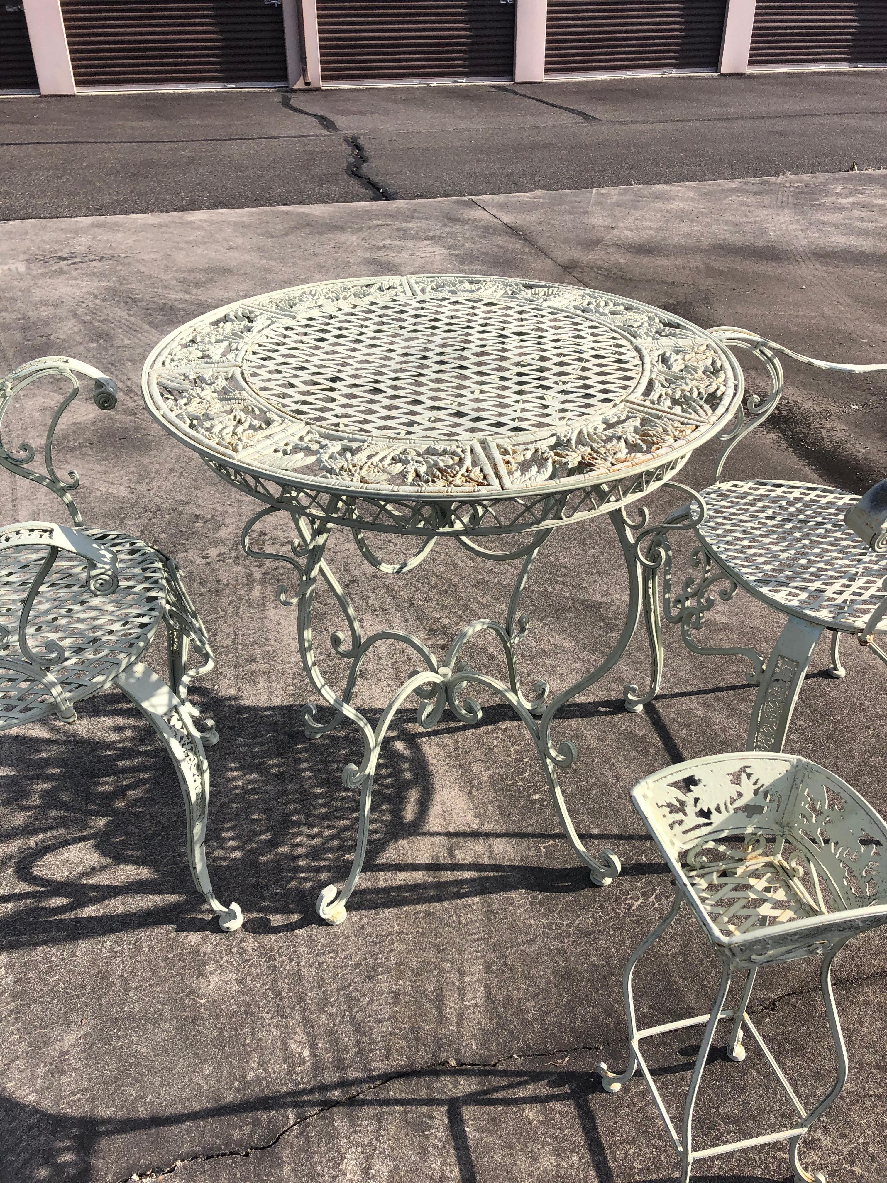 Vintage white painted round wrought iron patio bistro dining set with two matching armchairs and small planter.
Chairs measure: 22.75 W, 21 D, 39.75 H
Seat height 19.75, arm height 29.
 