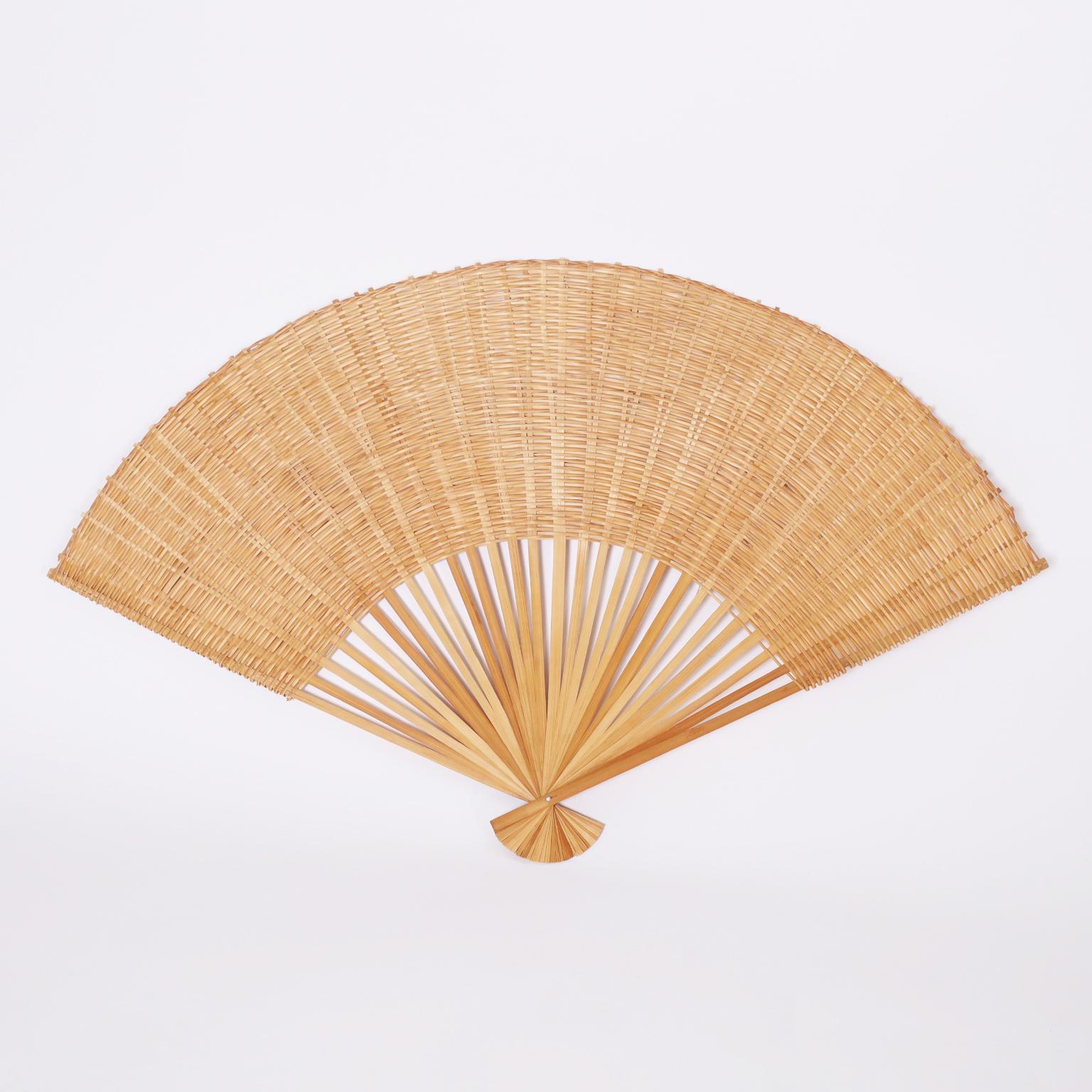 Unusual pair of vintage fans with plenty of decorative appeal hand crafted with stick wicker leaves over rattan ribs.