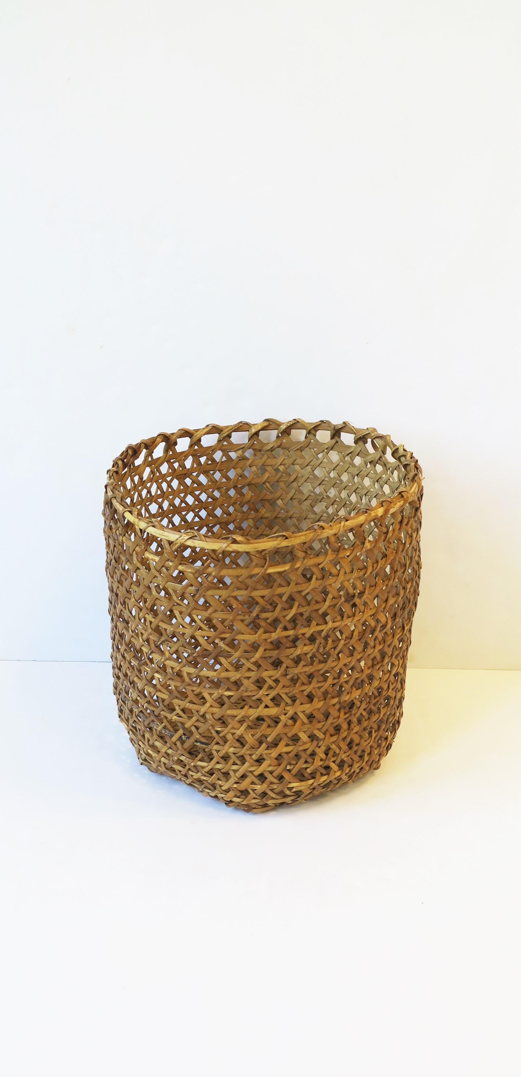 A beautiful hand-weaved vintage wicker 'basket' planter cachepot (plant pot holder) or wastebasket trash can, circa mid to late-20th century. Dimensions: 13