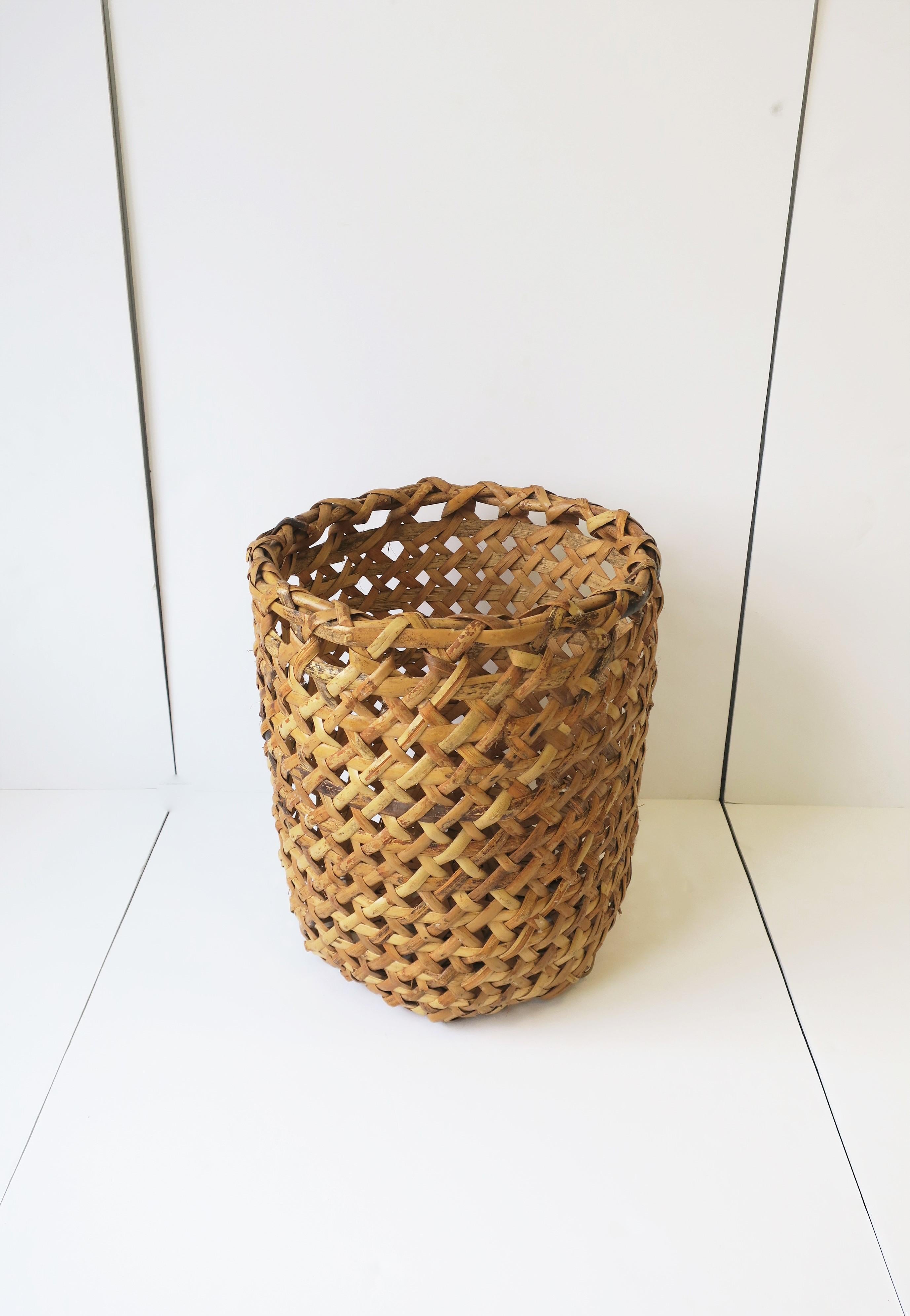 A beautiful and substantial hand-woven vintage wicker basket, circa mid-20th century. Basket could be decorative or used as a planter cachepot (plant pot holder), laundry basket hamper, a storage piece holding clean rolled towels for a shower, bath,