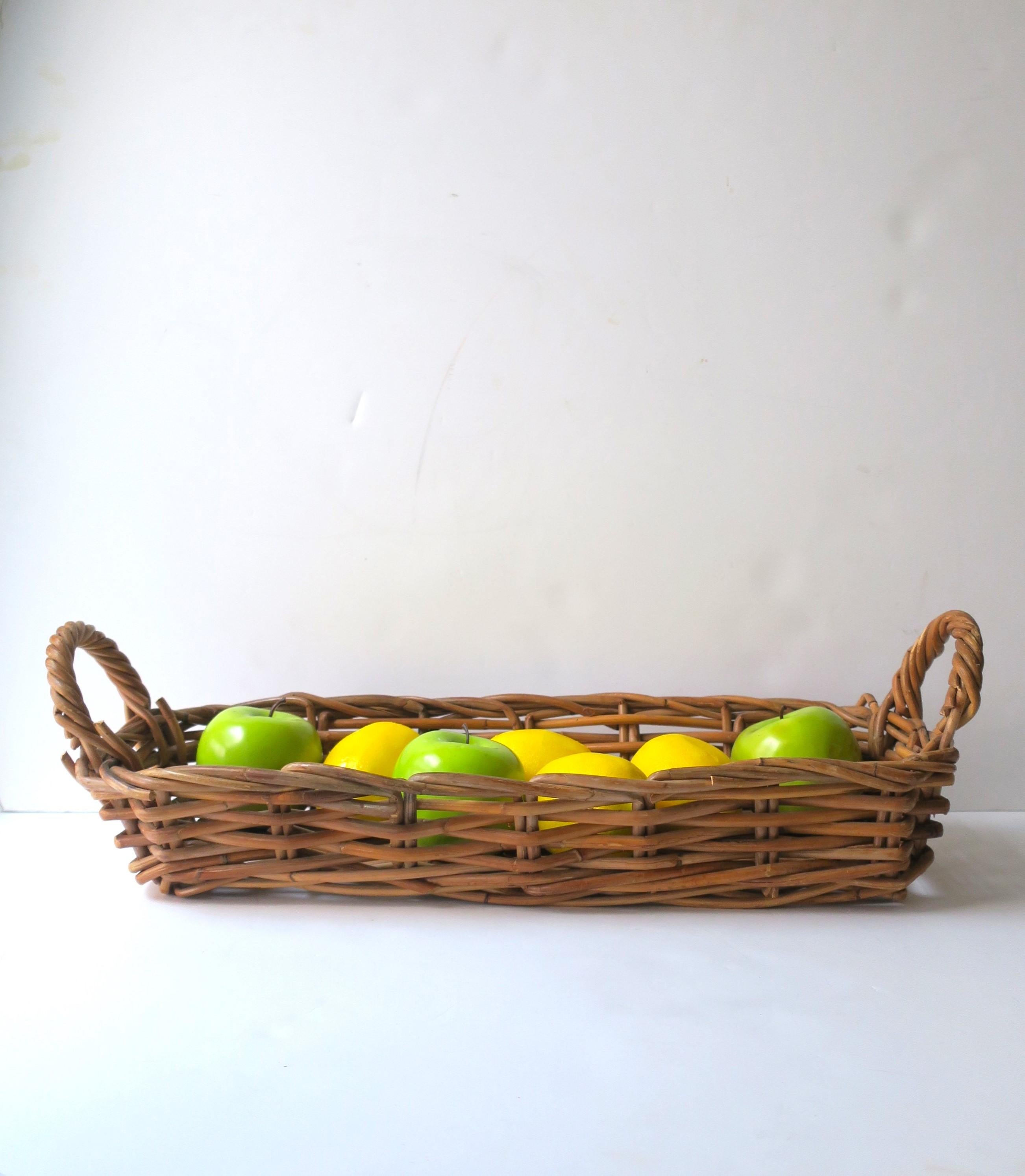 A wicker basket, oblong, with double handles, circa mid-20th century, USA. A great piece to hold or display items such a fruit (as demonstrated), vegetables, as a breadbasket, to hold plants/flowers, etc. Many uses. Dimensions: 8