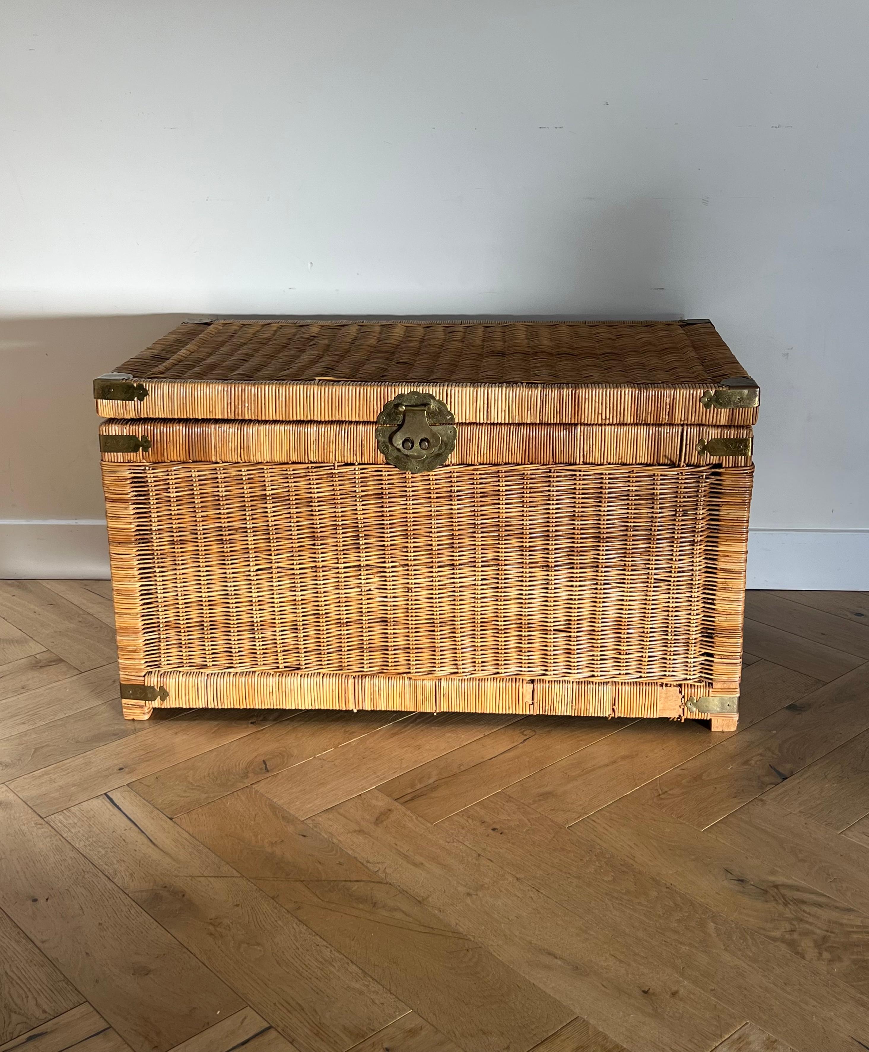 A vintage hand-woven wicker rattan chest for storage or blankets etc from south east Asia, late 20th century. Brass hardware depicts engraved birds and geometric oriental motif and symbols. Some wear and tear, such as a few “balding” spots where the