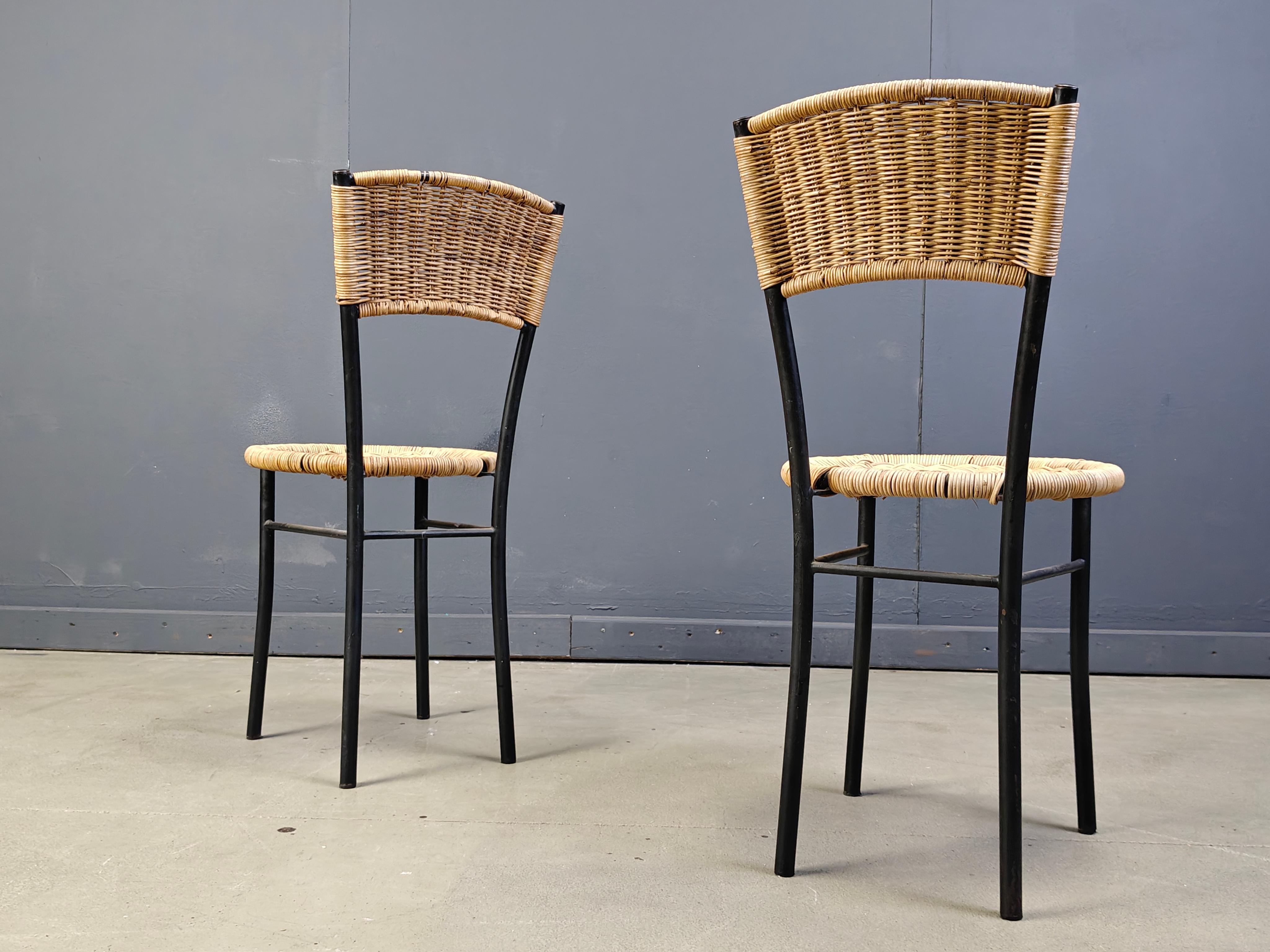 Eleganza delle sedie da pranzo in vimini con eleganti strutture in metallo nero.

Ottimo per l'utilizzo sia in interni che in esterni.

Buone condizioni generali.

anni '80 - Italia

Dimensioni:
Altezza: 83 cm
Larghezza: 40 cm
Profondità: 40