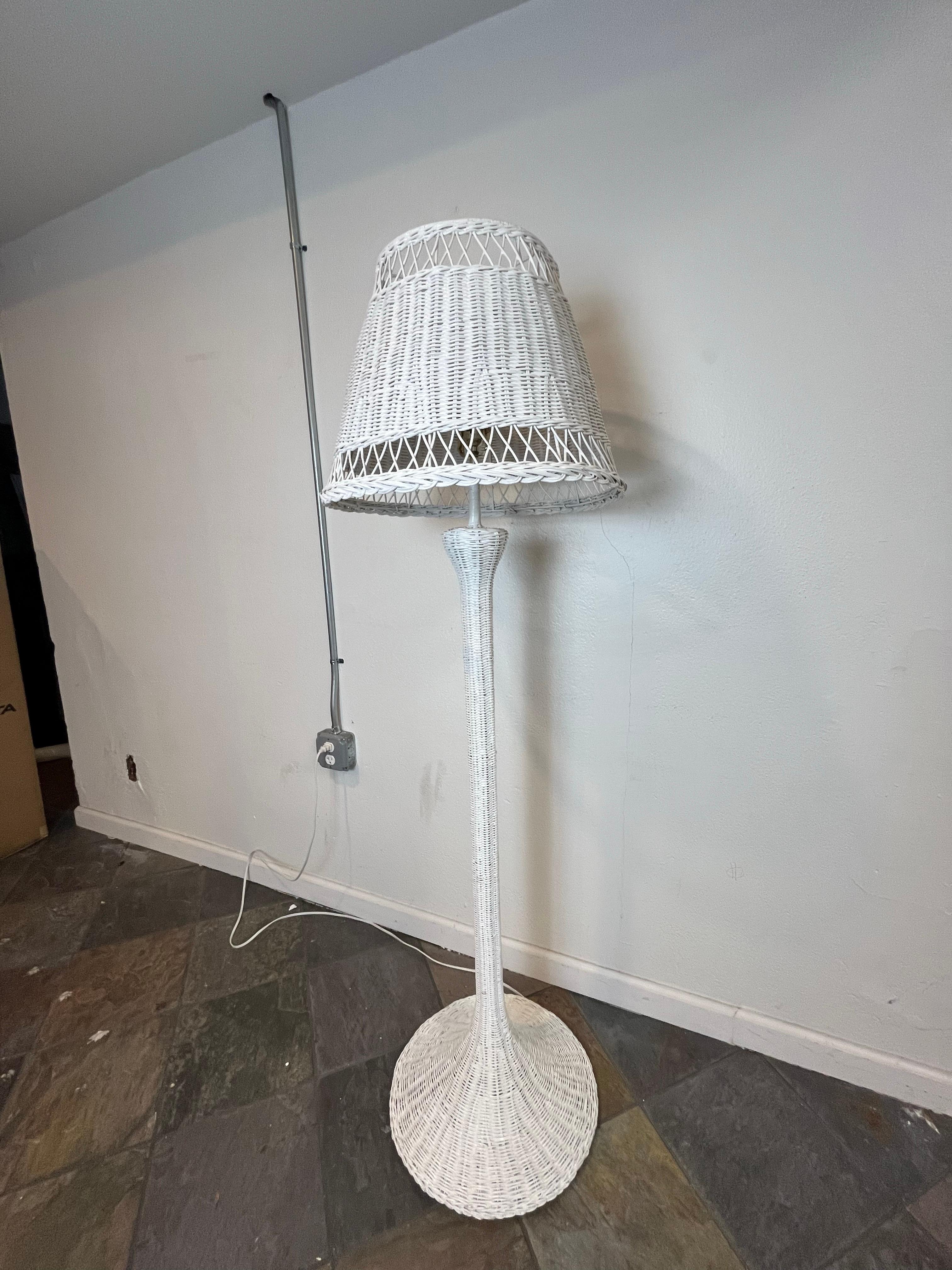 La lampada da terra vintage presenta una struttura in vimini e un terminale in ottone. Si erge a 62