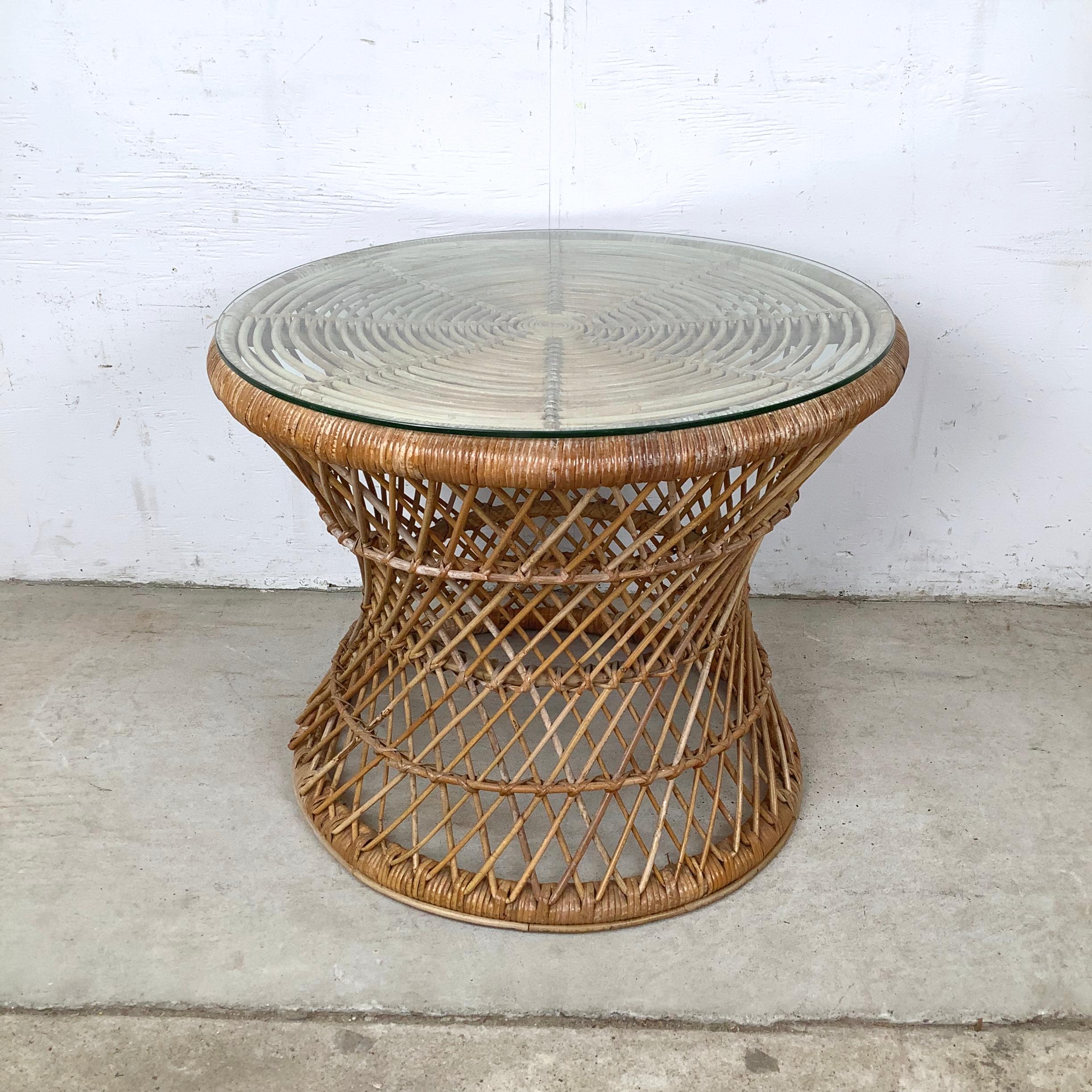 Cette table d'appoint en treillis de rotin présente une belle base tressée associée à un plateau rond en verre, créant un look à la fois aérien et sculptural. Le tissage ouvert crée un motif rythmique entrecroisé, donnant de la texture à la table
