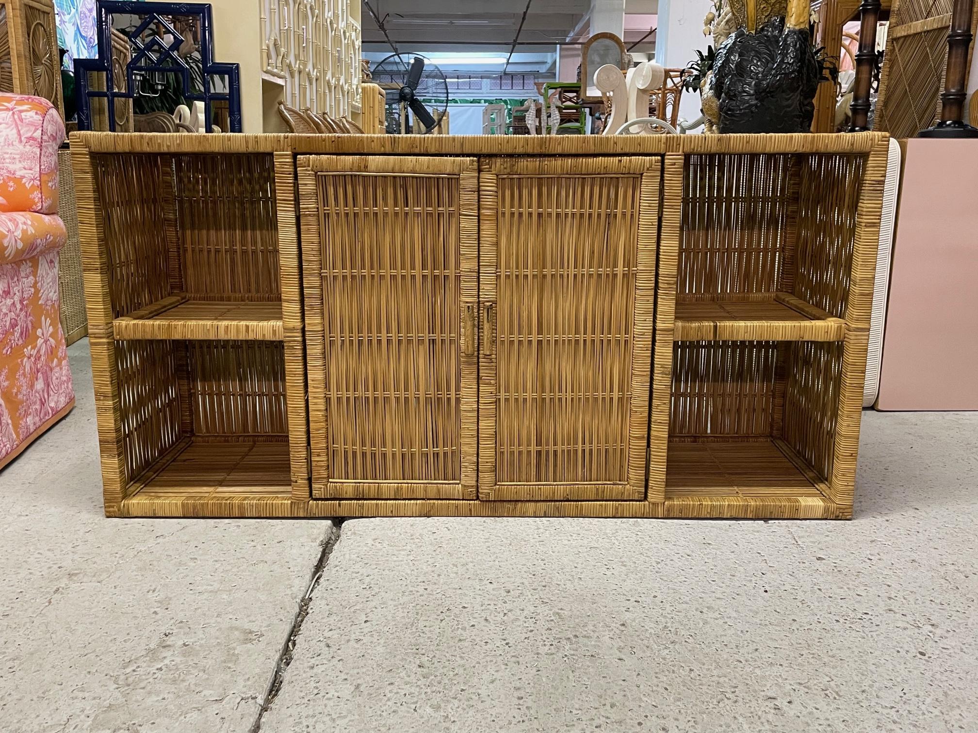 Vintage credenza or buffet feature a woven wicker design with double doors, shelving for display, and a smoked glass top. Good condition with imperfections consistent with age (see photos).
Shipping to most of the continental US is $250 to $500