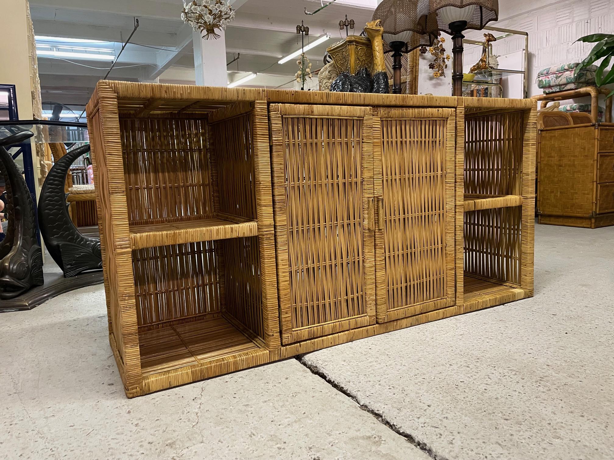Vintage credenza or buffet feature a woven wicker design with double doors, shelving for display, and a smoked glass top. Good condition with imperfections consistent with age, see photos for condition details.