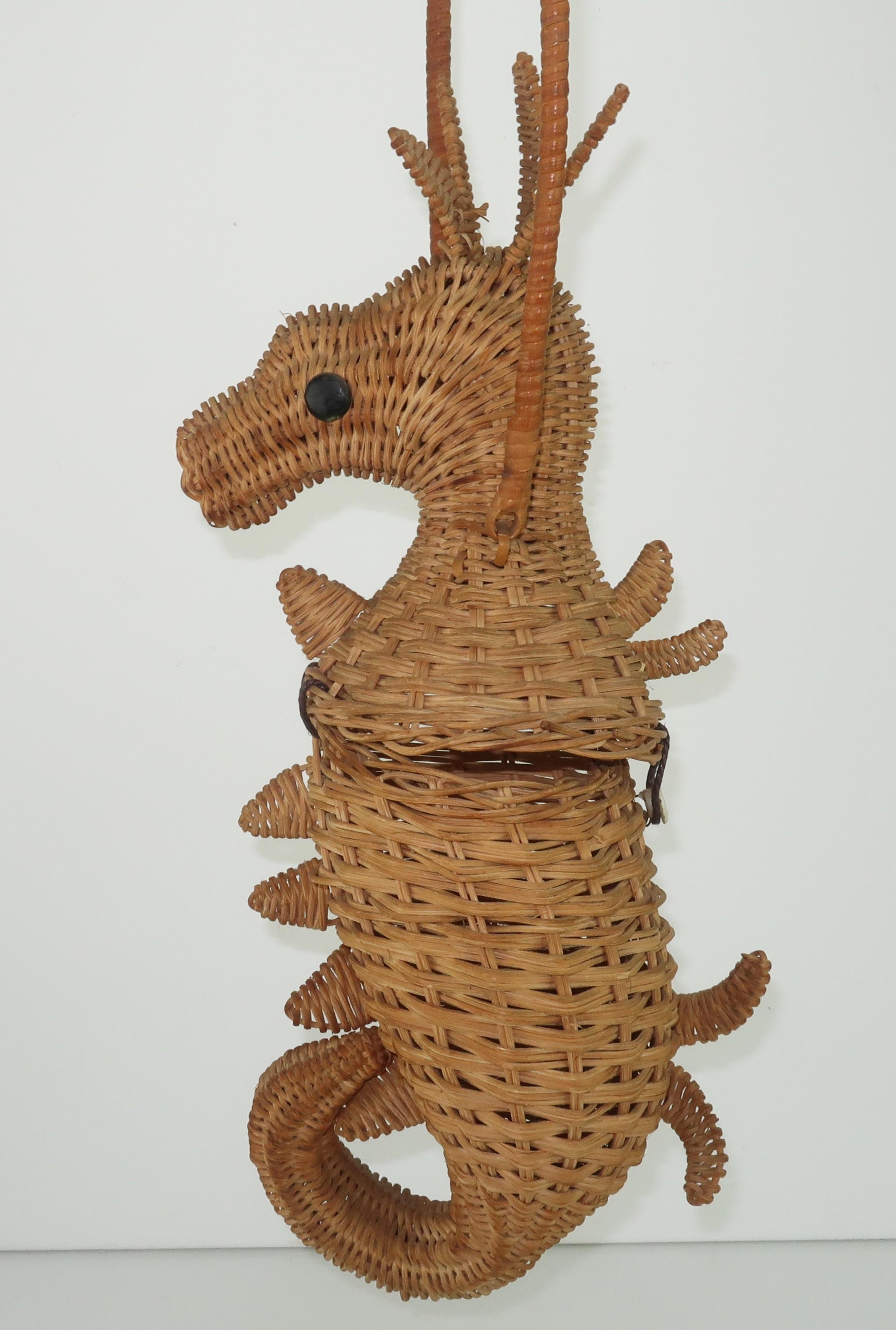 Adorable wicker seahorse handbag complete with fins, coronet, curled tail and black button eyes.  It sports a wicker handle and a button closure which opens to reveal a modest cone shaped interior.  Please note the Greta Plattry crochet two piece
