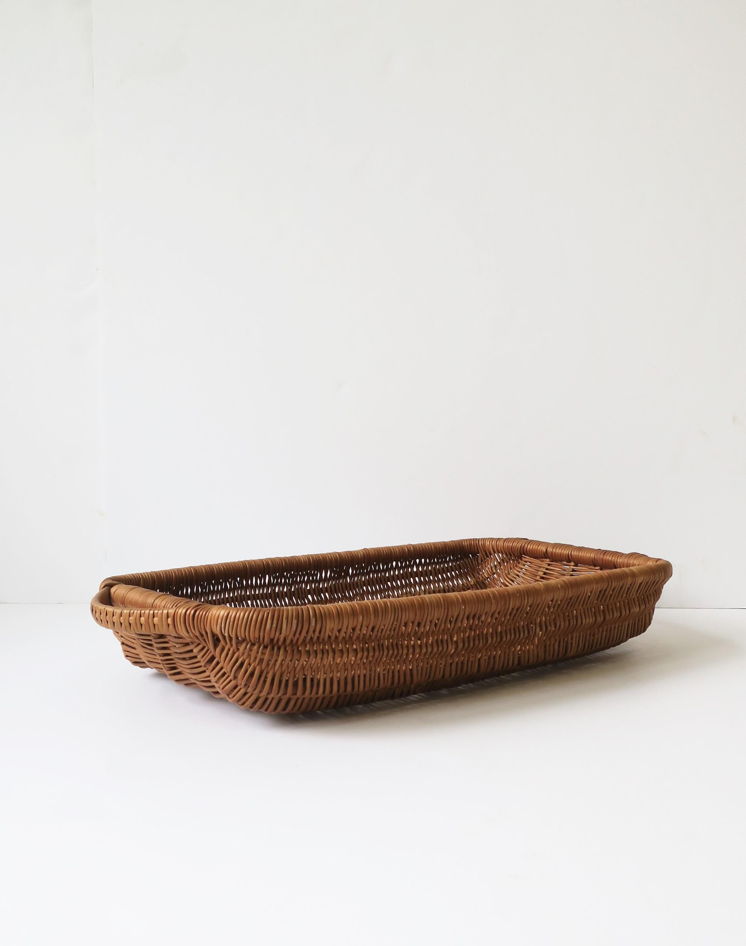 A beautiful and well-made rectangular wicker tray serving basket with handles, circa mid to late-20th century. A great piece for dining/entertaining or for gathering in the garden. Dimensions: 3.25