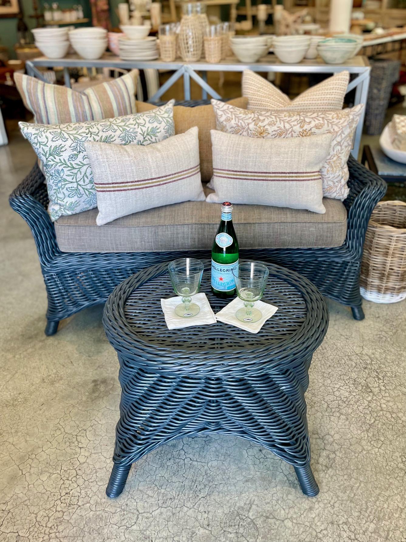 Il luogo perfetto per una lettura pomeridiana o per condividere un tè a due. Questo grazioso divanetto vintage in vimini è stato verniciato di recente in un rilassante blu/grigio e abbinato a un cuscino imbottito di recente in un classico lino color