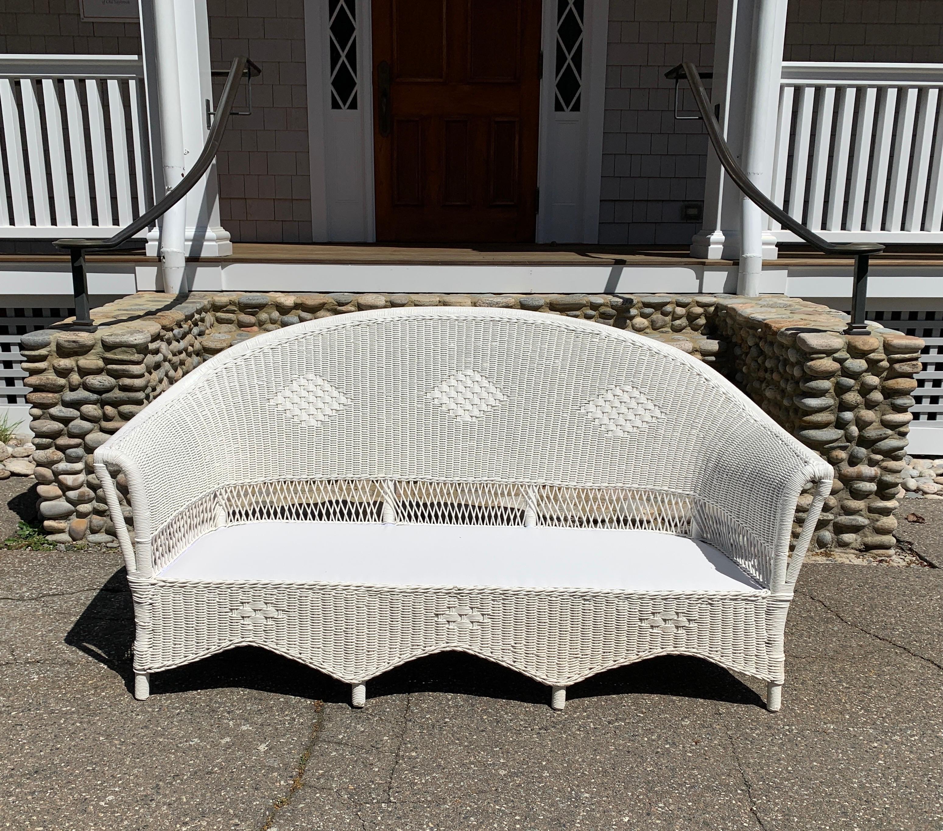 A traditional 1920's wicker porch set freshly painted white. Sofa measures 70