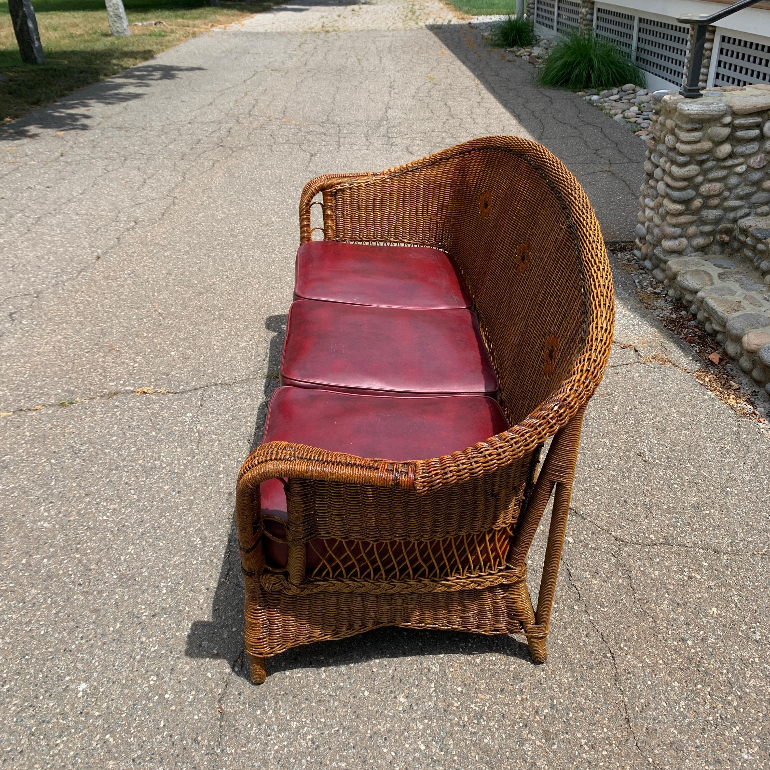 Antique wicker sofa in original stained finish. Original box springs seats covered in vinyl. Measures: 72” wide by 34” tall by 30” deep. Handwoven by The Brighton Furniture Company of Vermont in the early 1900s.