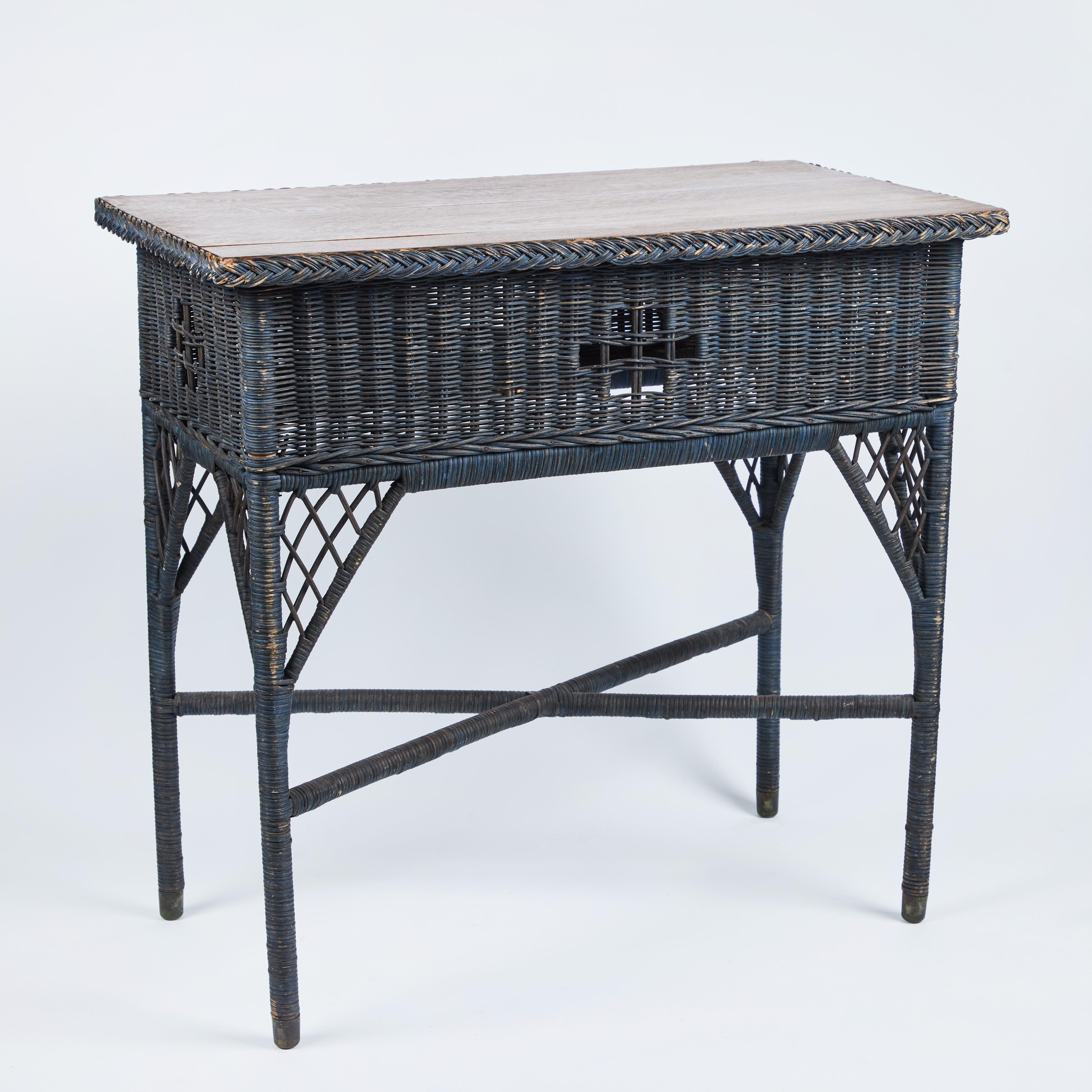 This perfect small vintage wicker console table is a charmer. It has its original black painted finish, a lovely oak wood top with braided wicker border detailing and brass feet.