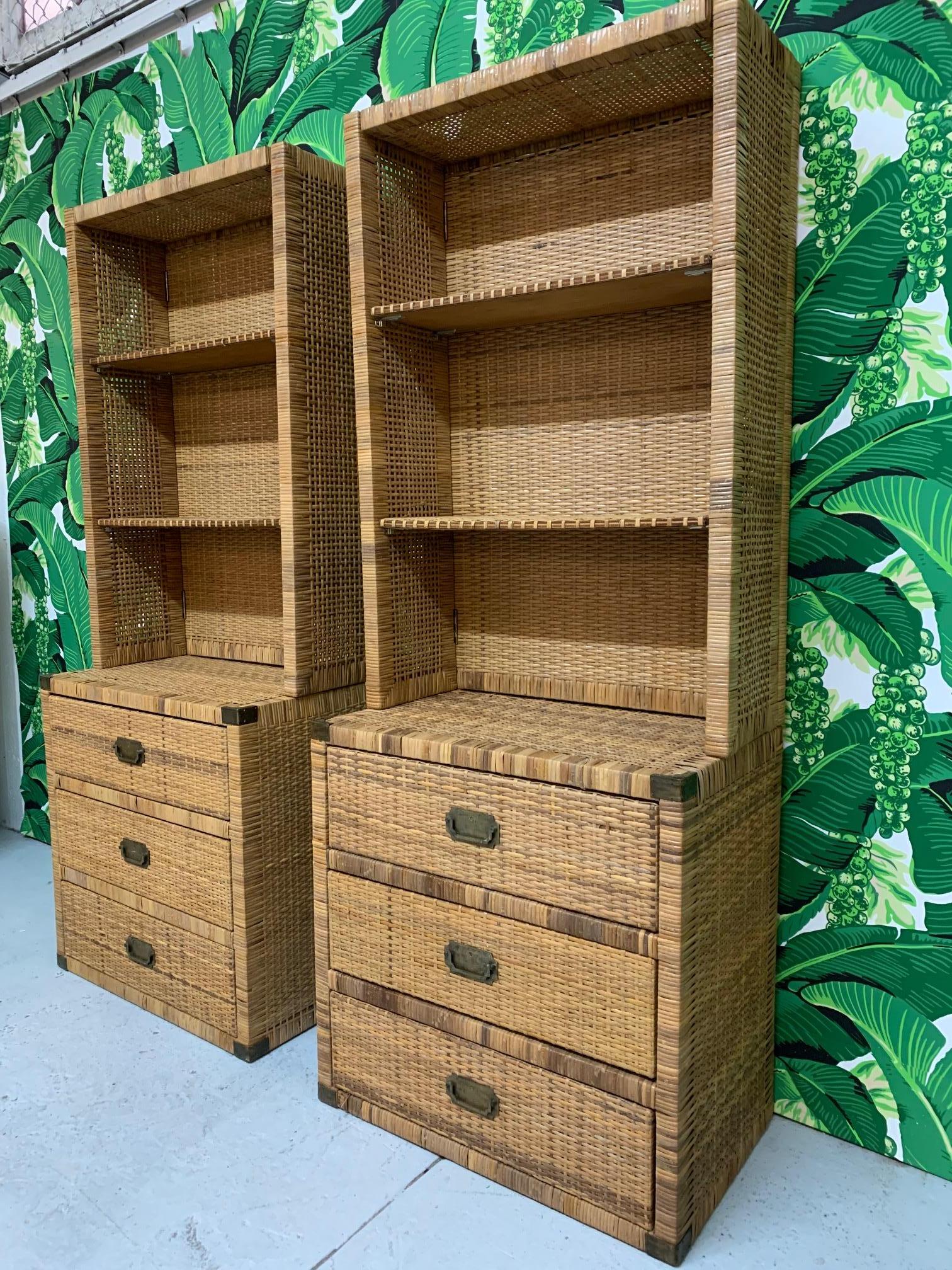 Vintage wicker wall unit consists of two units, each with storage cabinets as a base and shelving on top. Shelving can be removed, and cabinets can be used as nightstands or end tables. Features brass hardware and brass corners in campaign style.