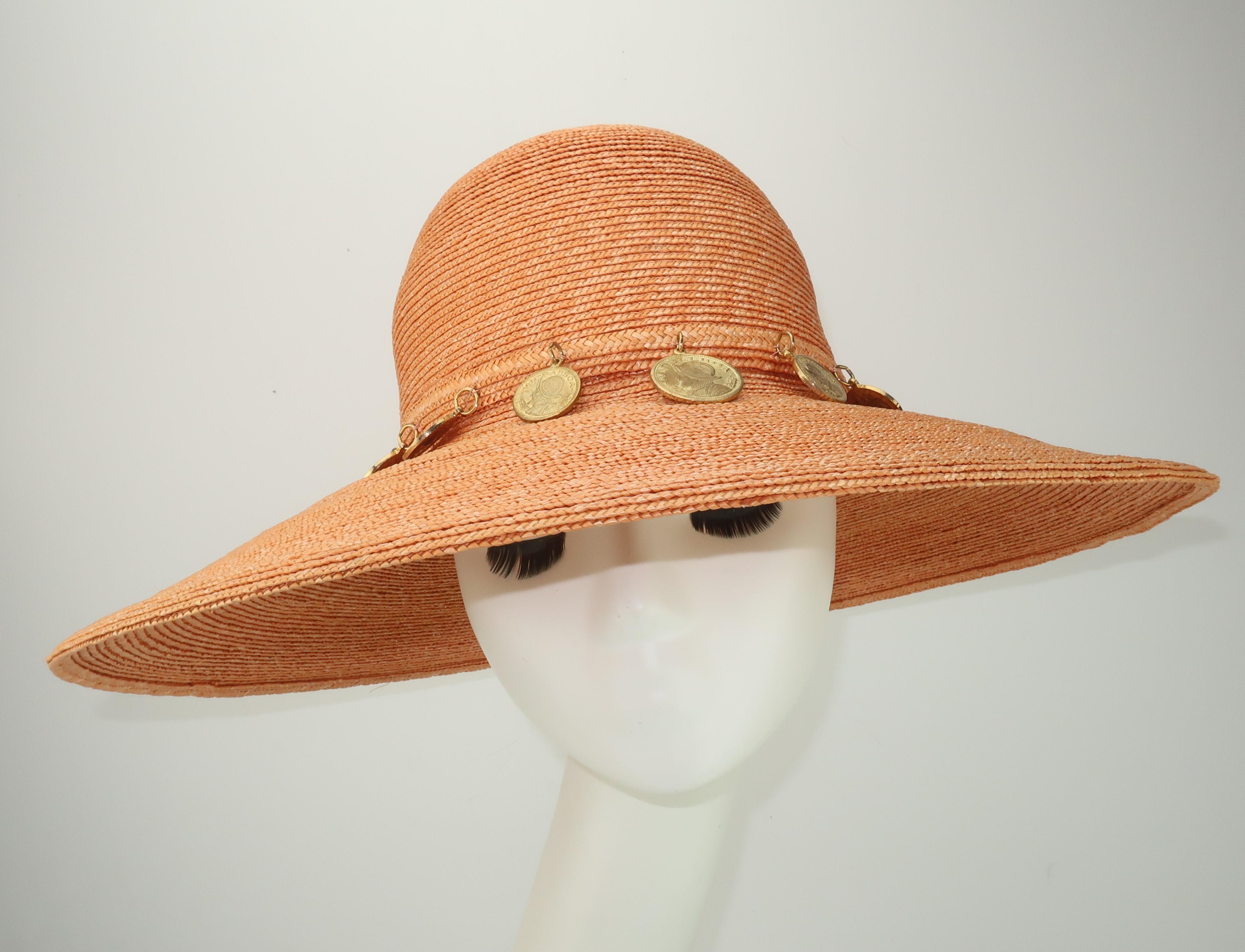 1980's wide brim hat in a cantaloupe orange straw (light enough to be neutral) accented by faux Spanish gold coins.  The inner rim is trimmed in a hot pink grosgrain ribbon.  Perfect for adding a chic style to beach wear or summertime casuals.  No